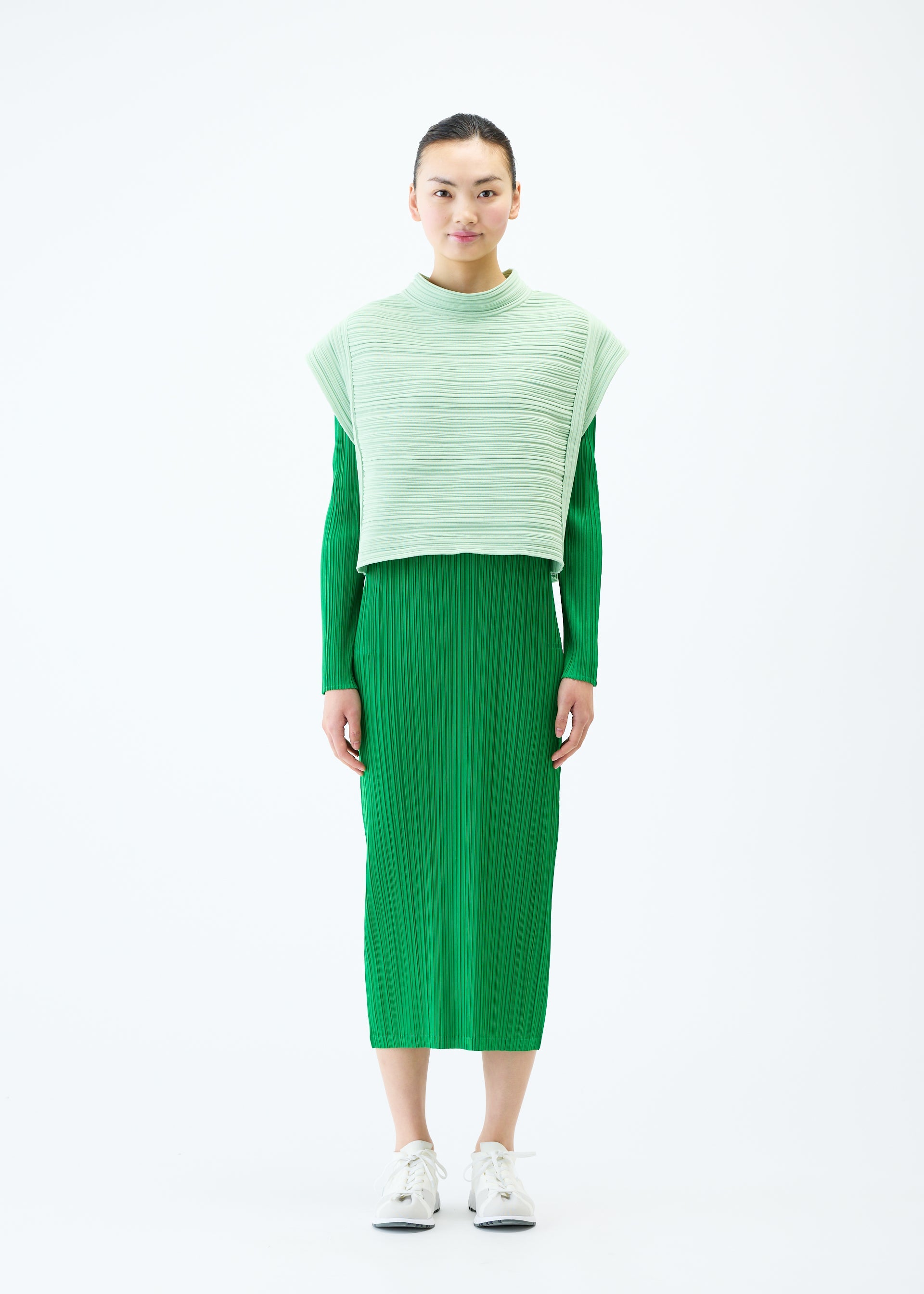 A model wears the PLEATS PLEASE ISSEY MIYAKE CREPE KNIT vest.