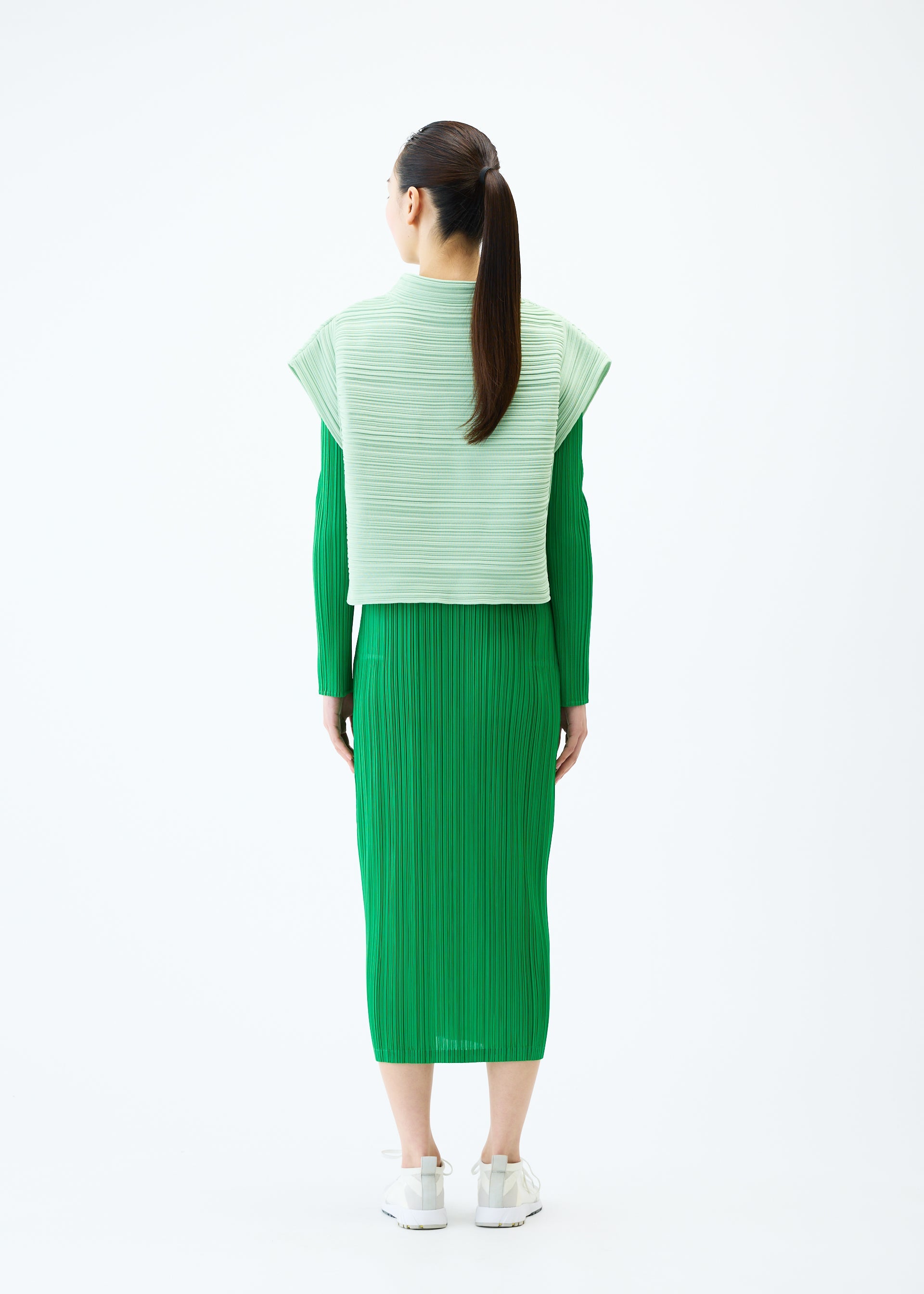 A model wears the PLEATS PLEASE ISSEY MIYAKE CREPE KNIT vest.