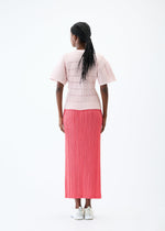 A model wears the PLEATS PLEASE ISSEY MIYAKE JIGGLY KNIT top.