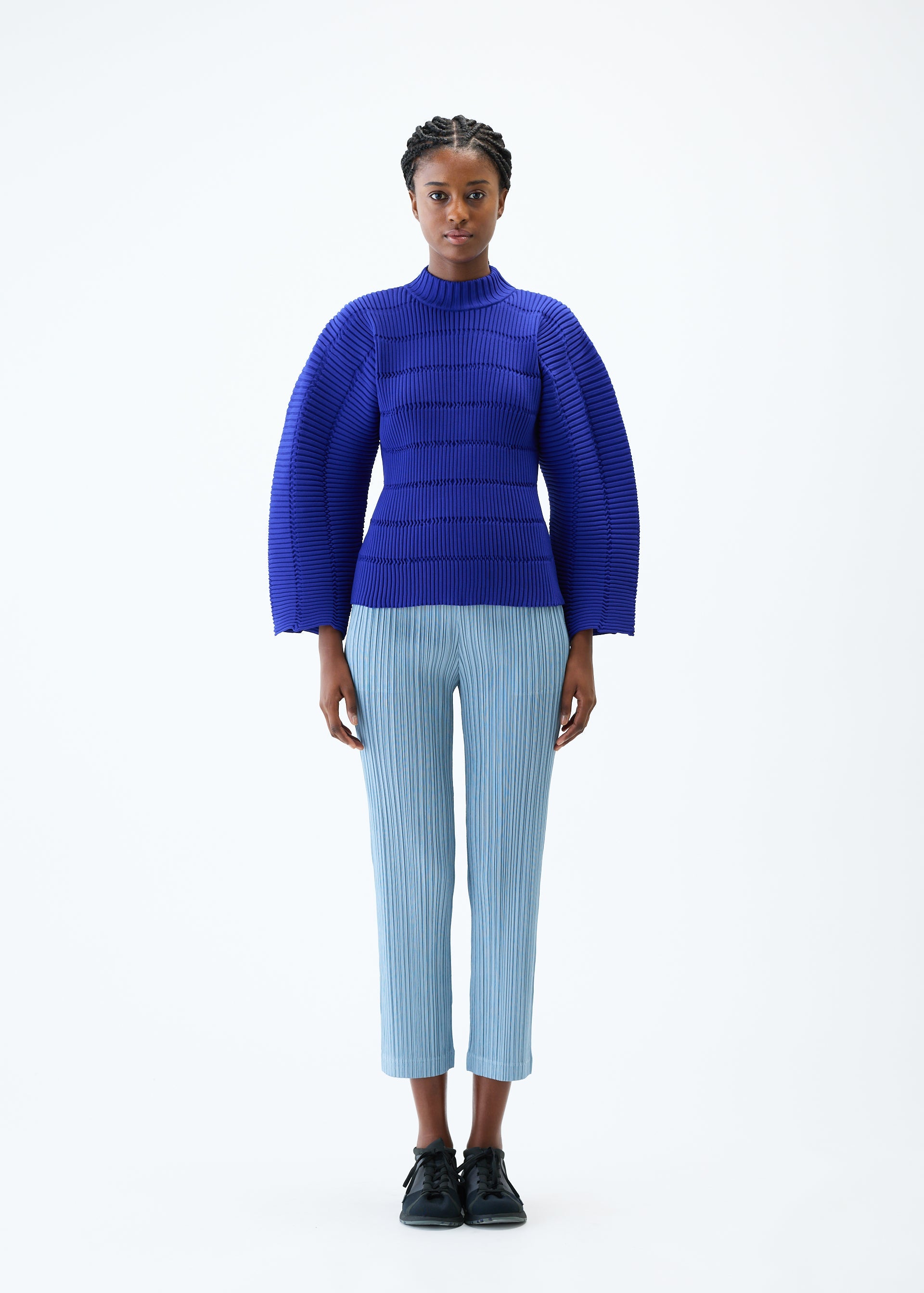 A model wears the PLEATS PLEASE ISSEY MIYAKE JIGGLY KNIT top.