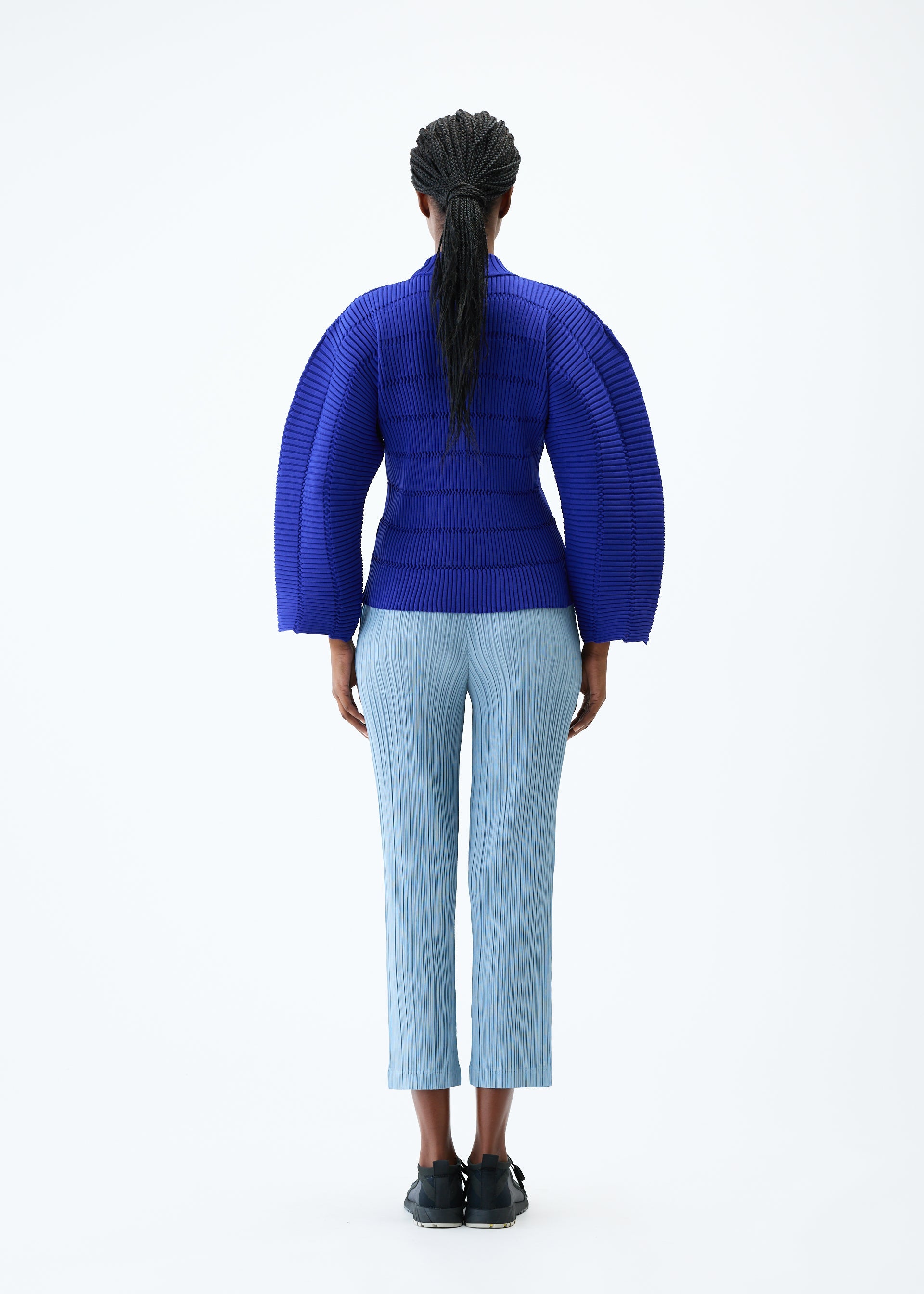 A model wears the PLEATS PLEASE ISSEY MIYAKE JIGGLY KNIT top.