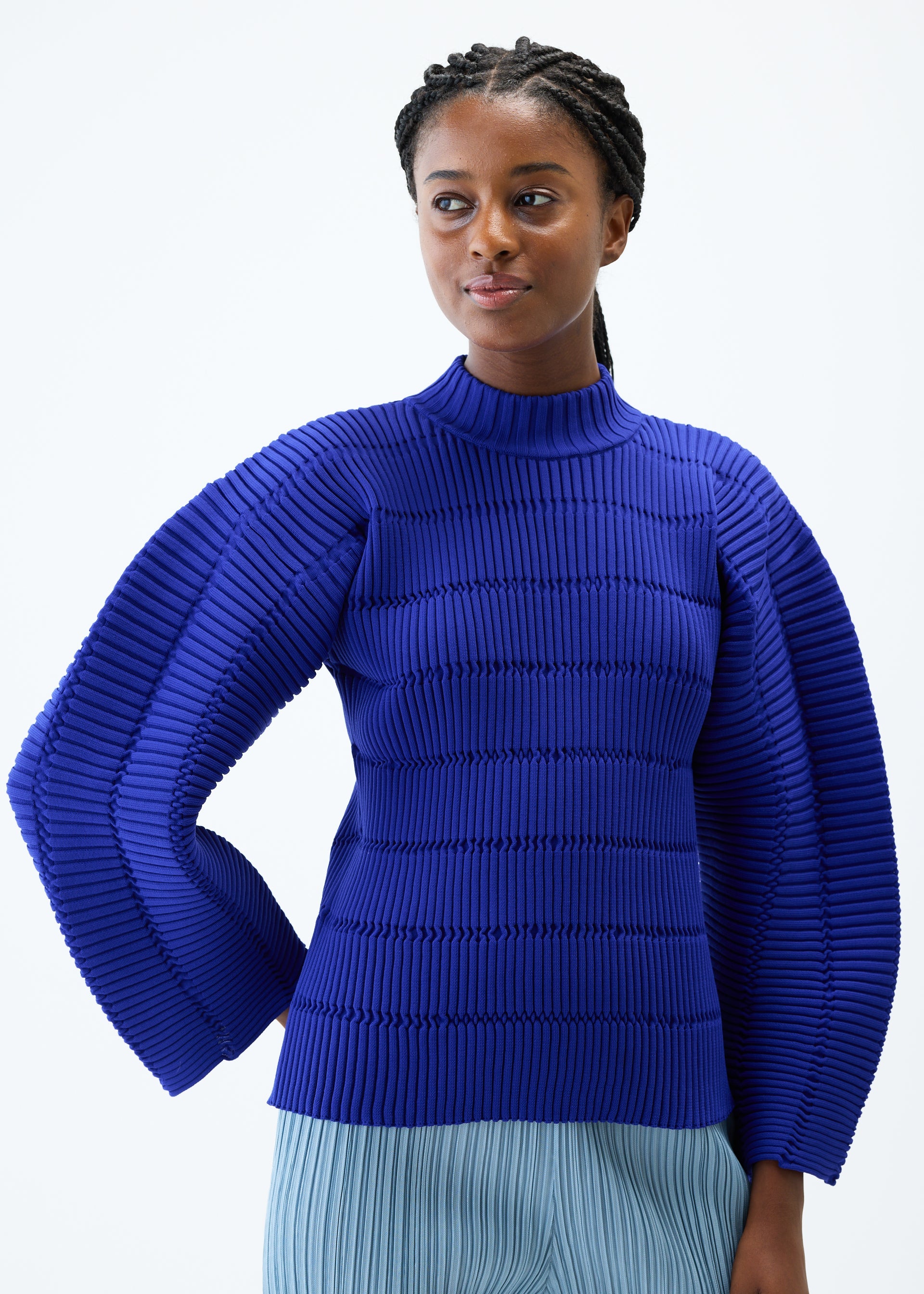 A model wears the PLEATS PLEASE ISSEY MIYAKE JIGGLY KNIT top.