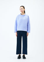 A model wears the PLEATS PLEASE ISSEY MIYAKE CREPE KNIT top.