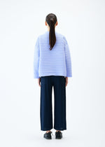 A model wears the PLEATS PLEASE ISSEY MIYAKE CREPE KNIT top.