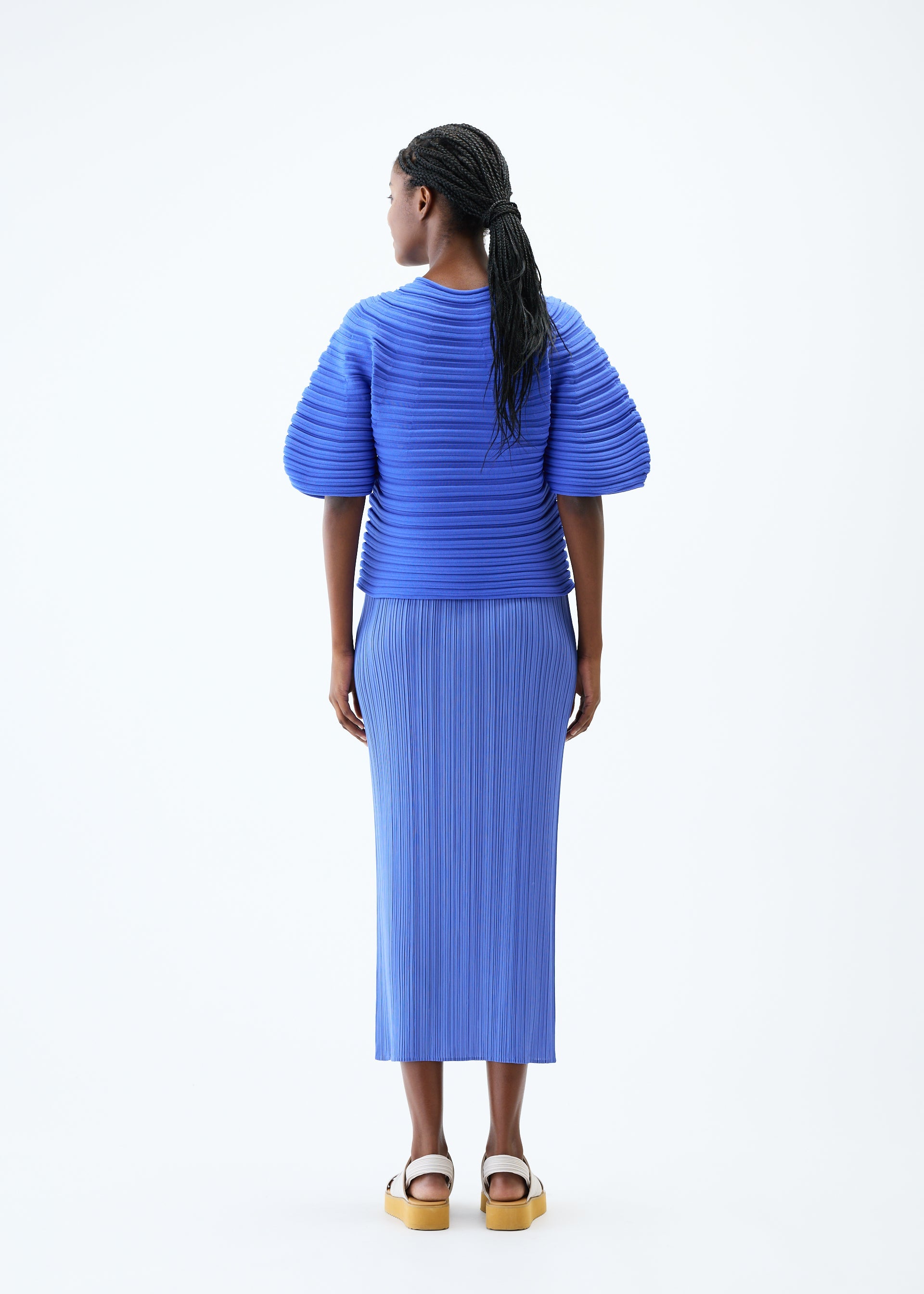 A model wears the PLEATS PLEASE ISSEY MIYAKE MUSHROOM KNIT top.