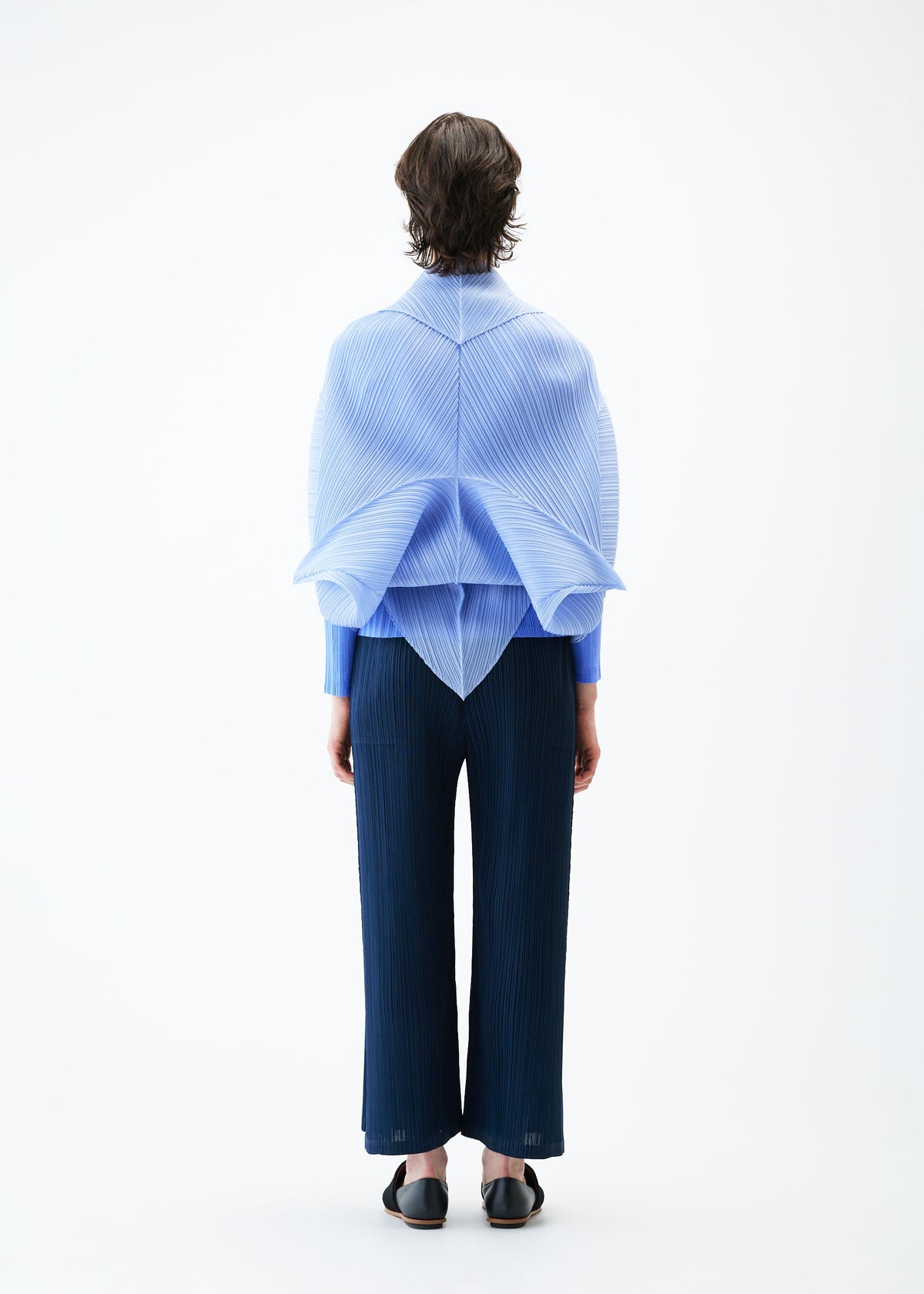 A model wears the PLEATS PLEASE ISSEY MIYAKE ZIGZAG PLEATS SCARF stole.