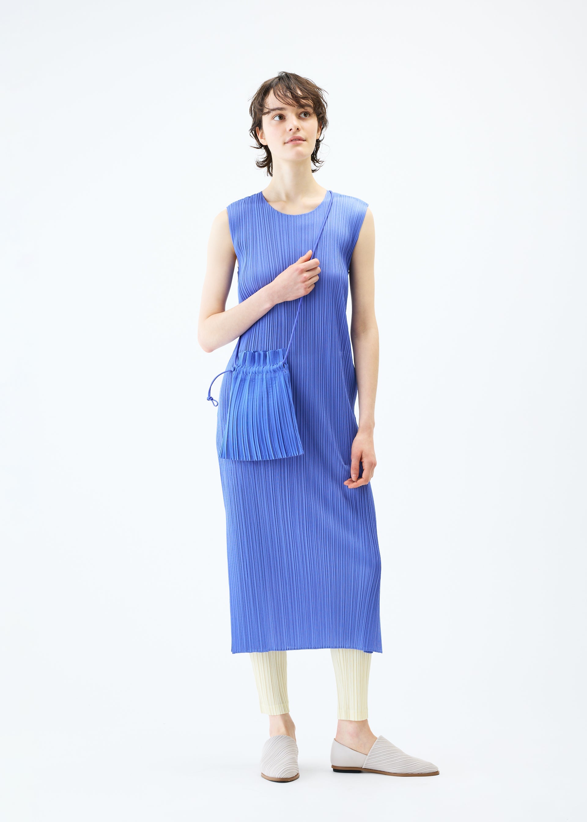 A model wears the PLEATS PLEASE ISSEY MIYAKE PLEATS MINI POCHETTE bag.