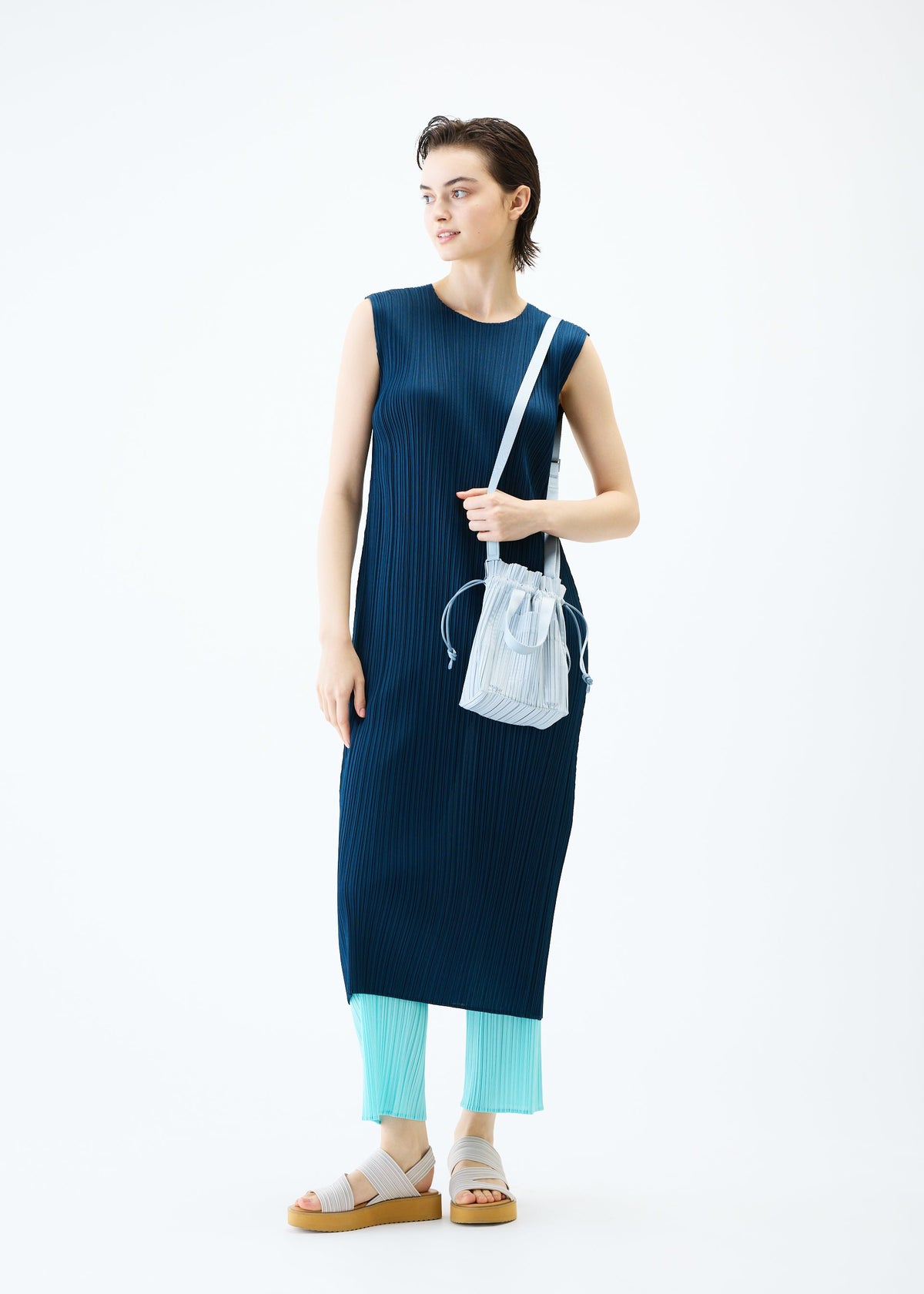 A model wears the PLEATS PLEASE ISSEY MIYAKE PLEATS TOTE BAG bag.