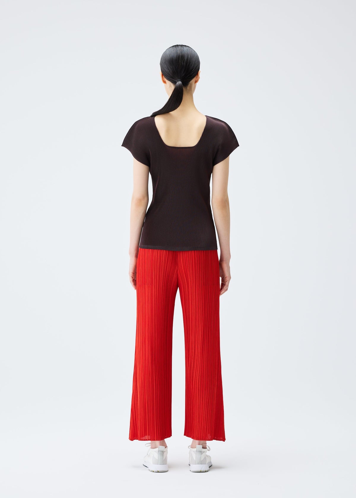 A model wears the PLEATS PLEASE ISSEY MIYAKE MIST JULY top.