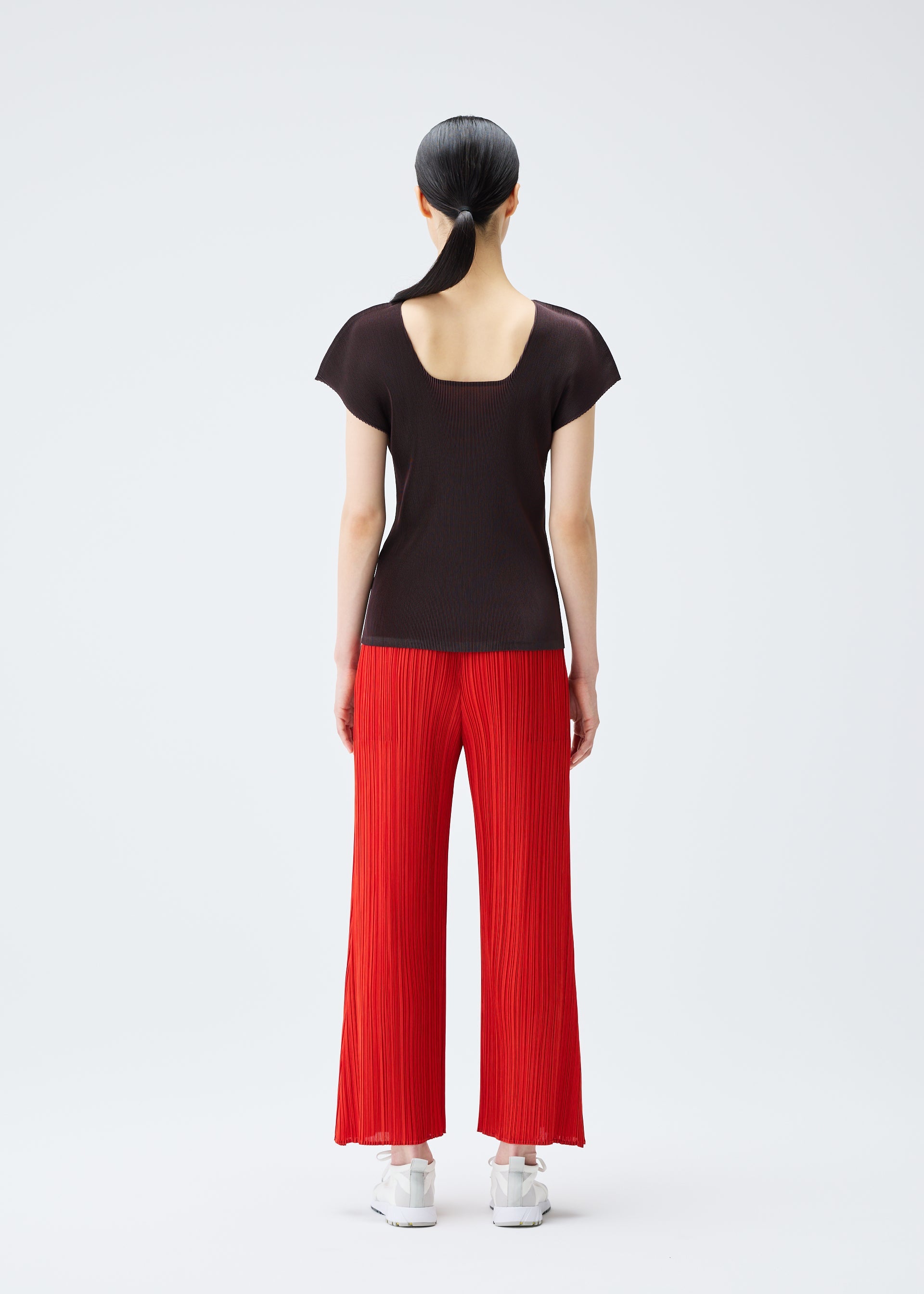 A model wears the PLEATS PLEASE ISSEY MIYAKE MIST JULY top.
