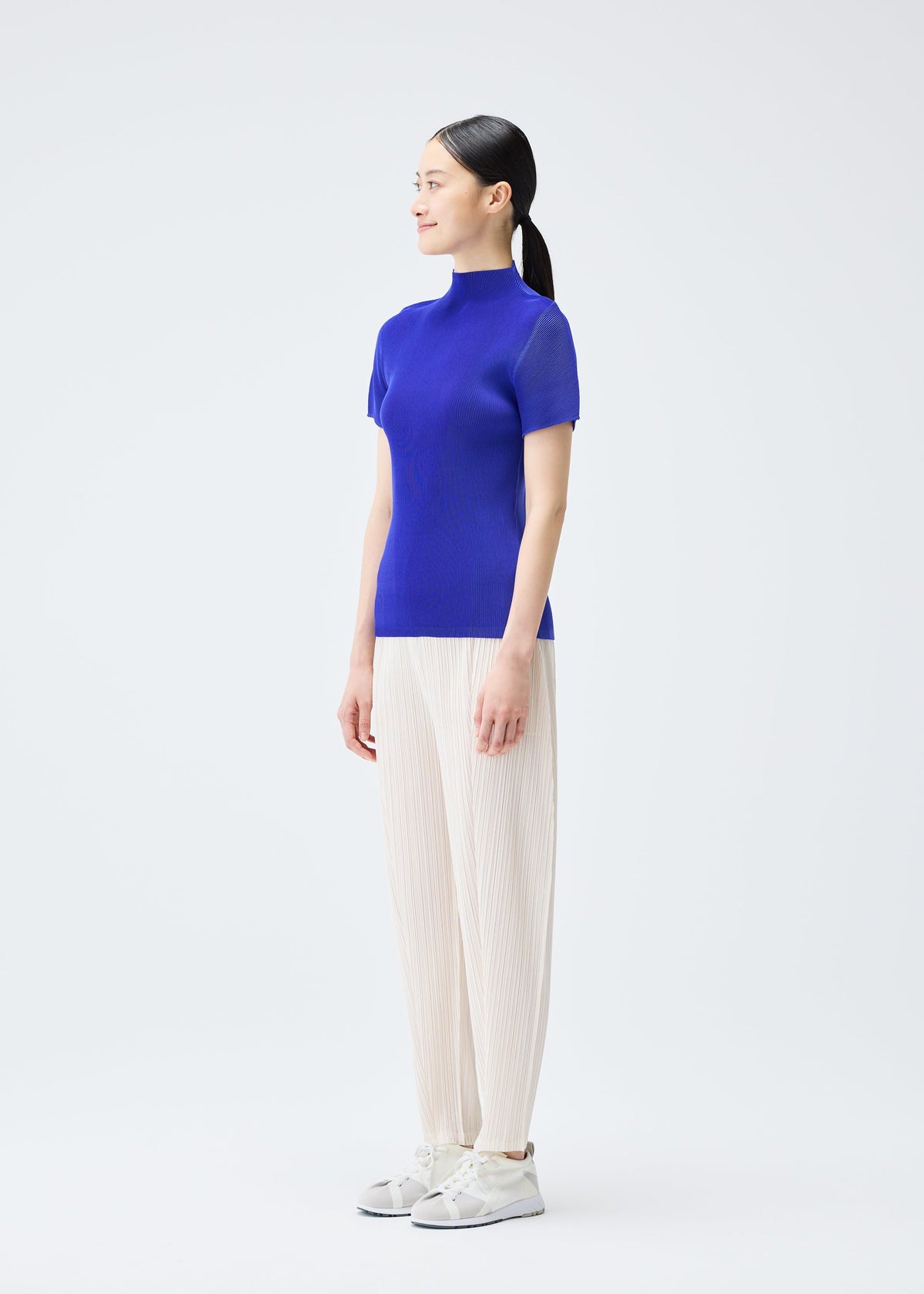 A model wears the PLEATS PLEASE ISSEY MIYAKE MIST SEPTEMBER top.