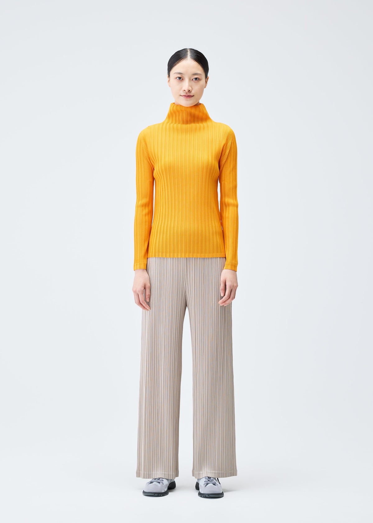 A model wears the PLEATS PLEASE ISSEY MIYAKE RIB PLEATS DECEMBER clothing.