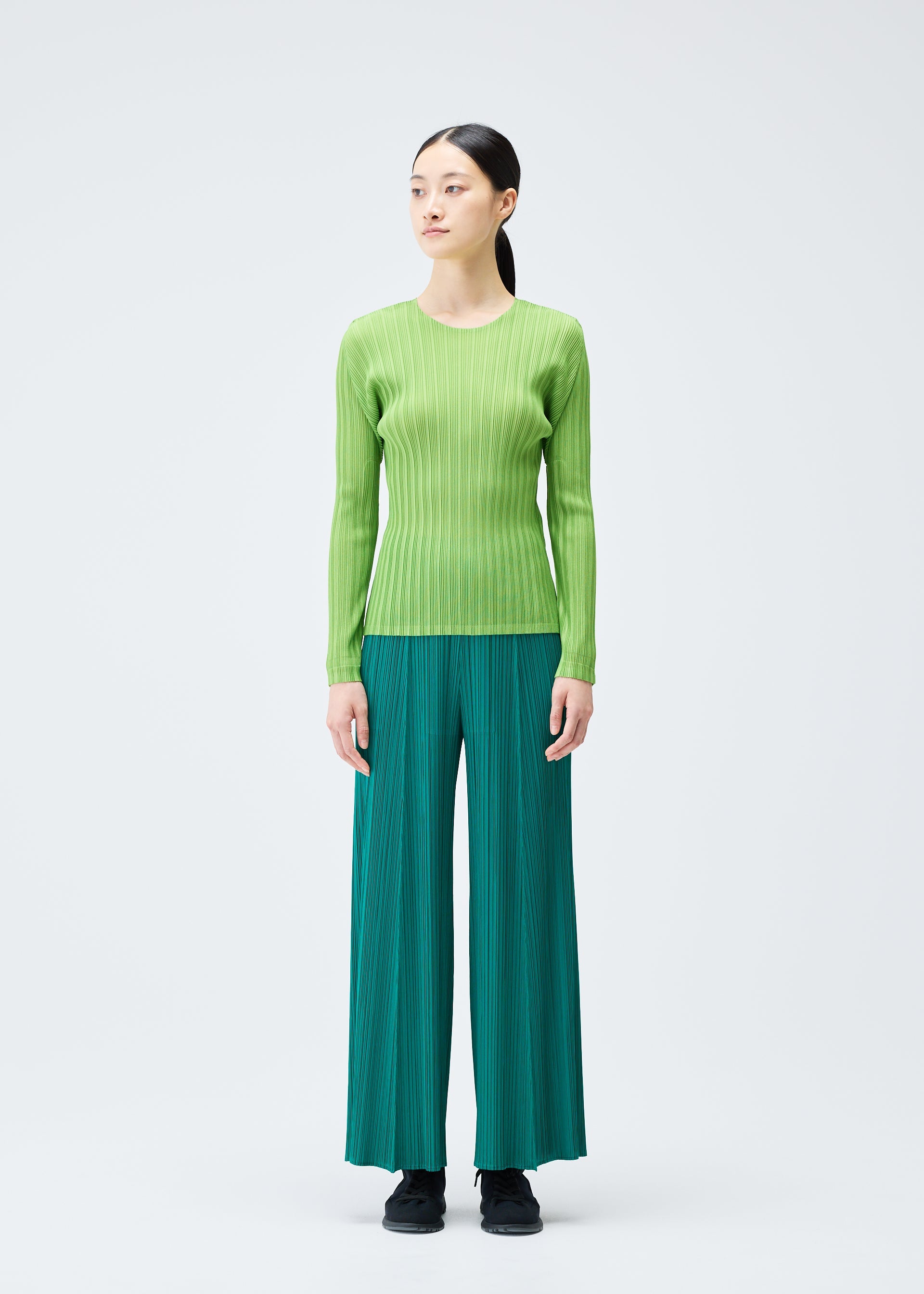 A model wears the PLEATS PLEASE ISSEY MIYAKE RIB PLEATS NOVEMBER top.