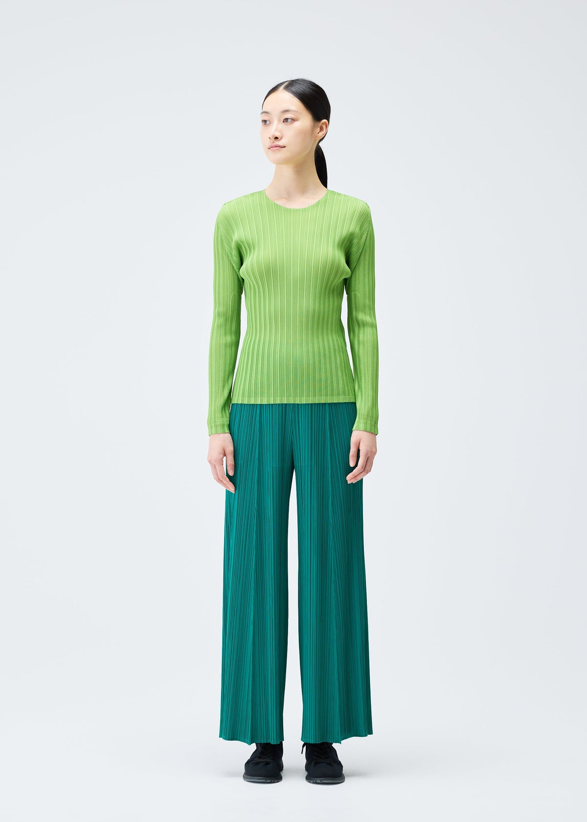 A model wears the PLEATS PLEASE ISSEY MIYAKE RIB PLEATS NOVEMBER top.