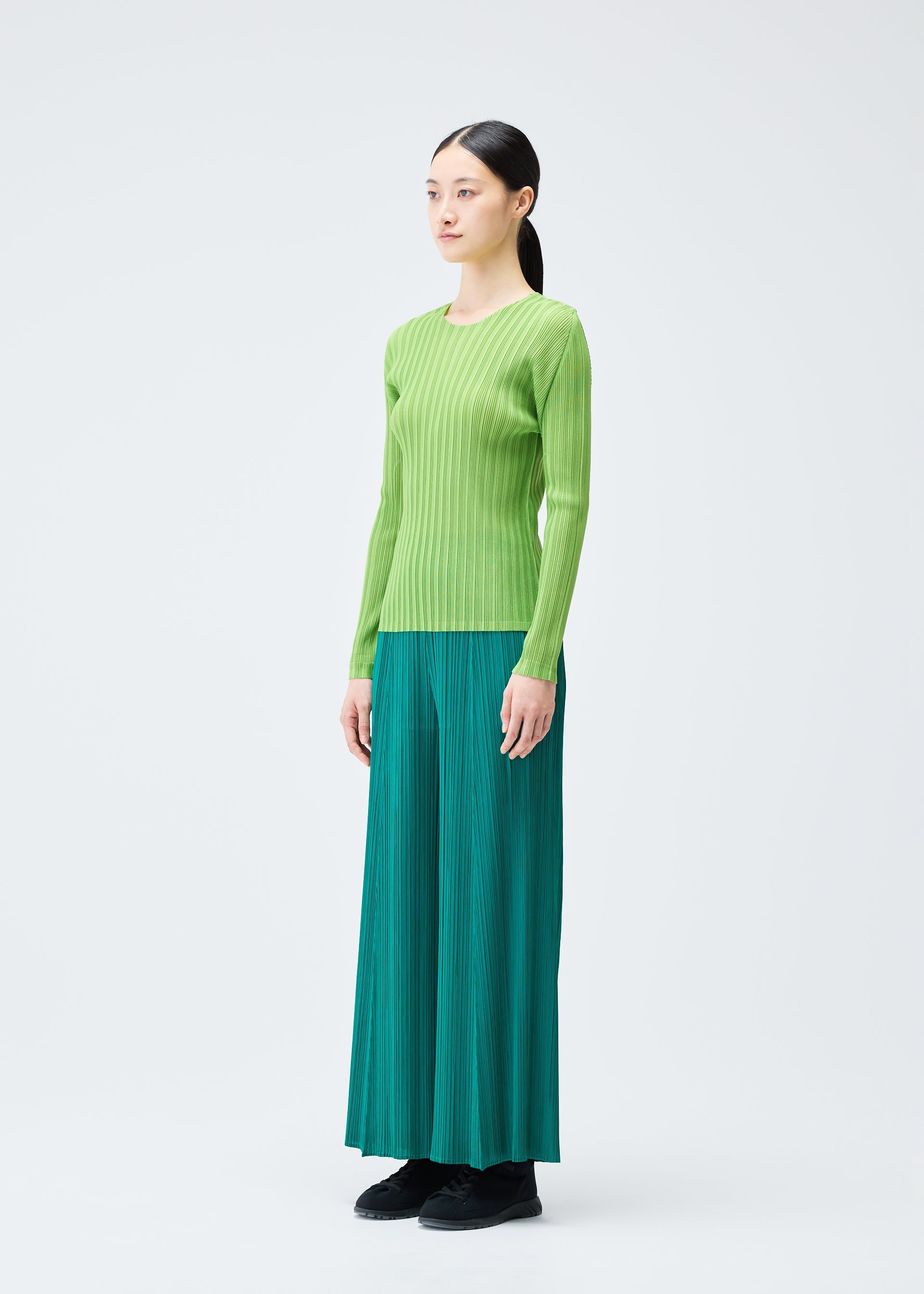 A model wears the PLEATS PLEASE ISSEY MIYAKE RIB PLEATS NOVEMBER top.
