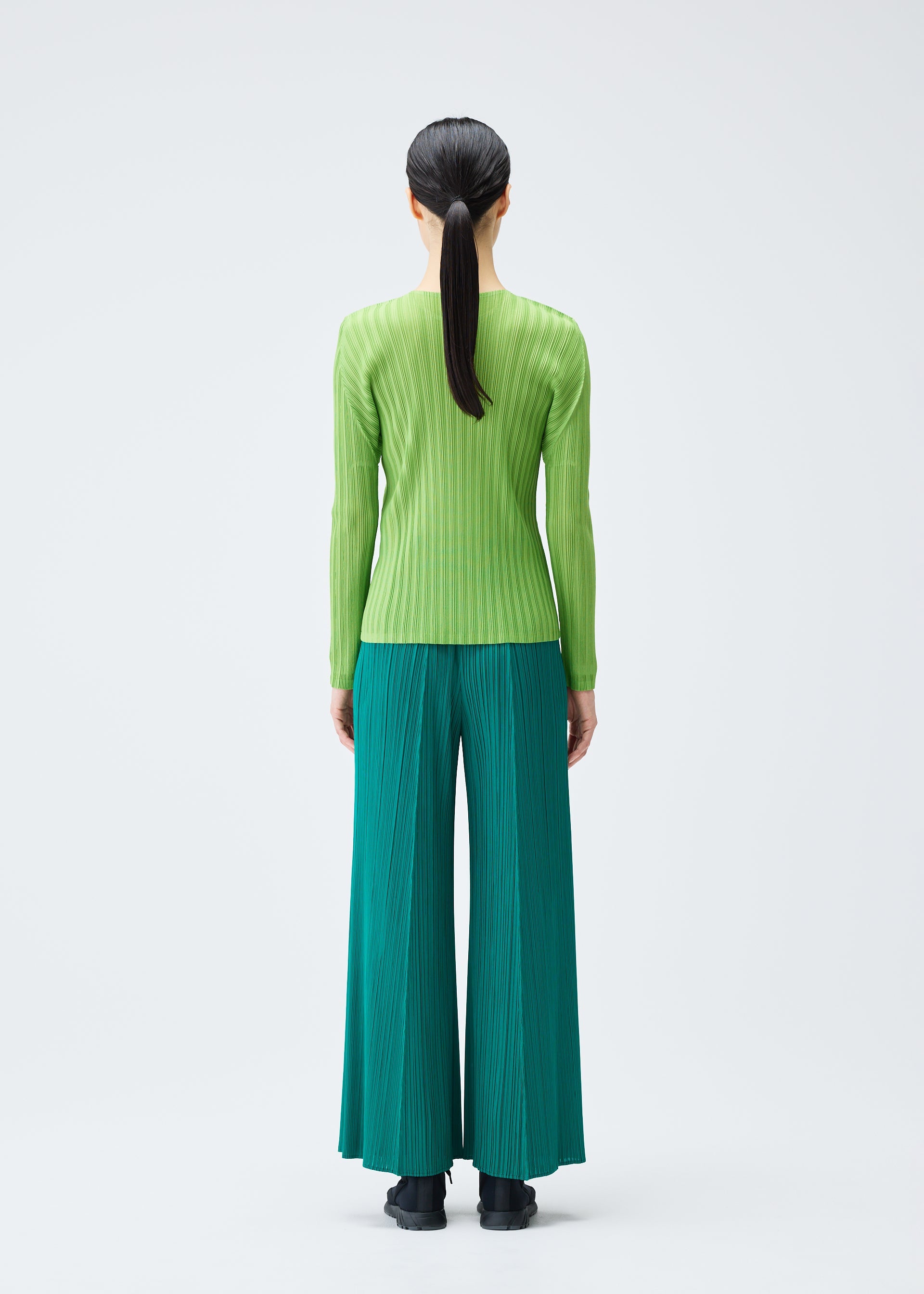 A model wears the PLEATS PLEASE ISSEY MIYAKE RIB PLEATS NOVEMBER top.
