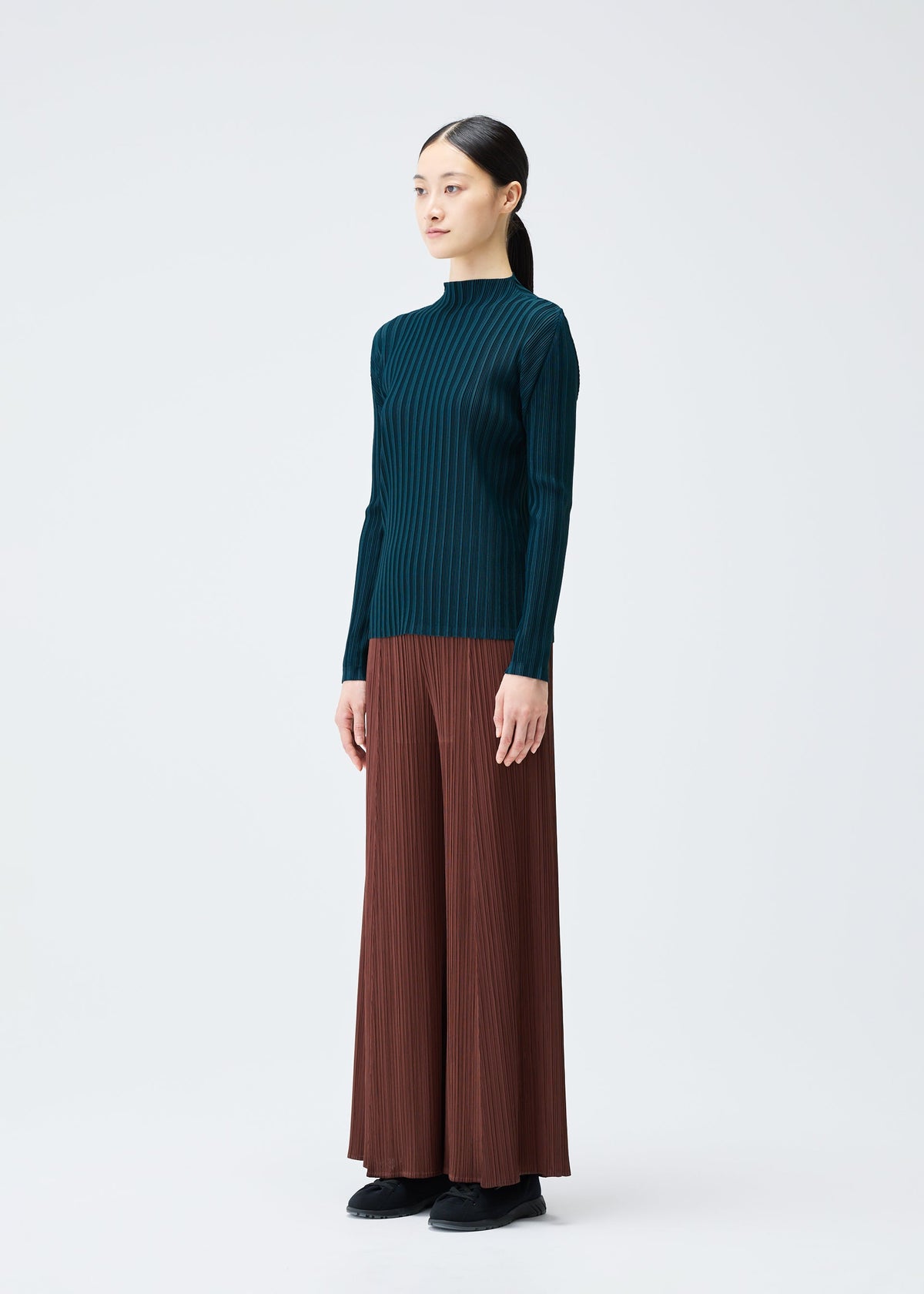 A model wears the PLEATS PLEASE ISSEY MIYAKE RIB PLEATS NOVEMBER top.