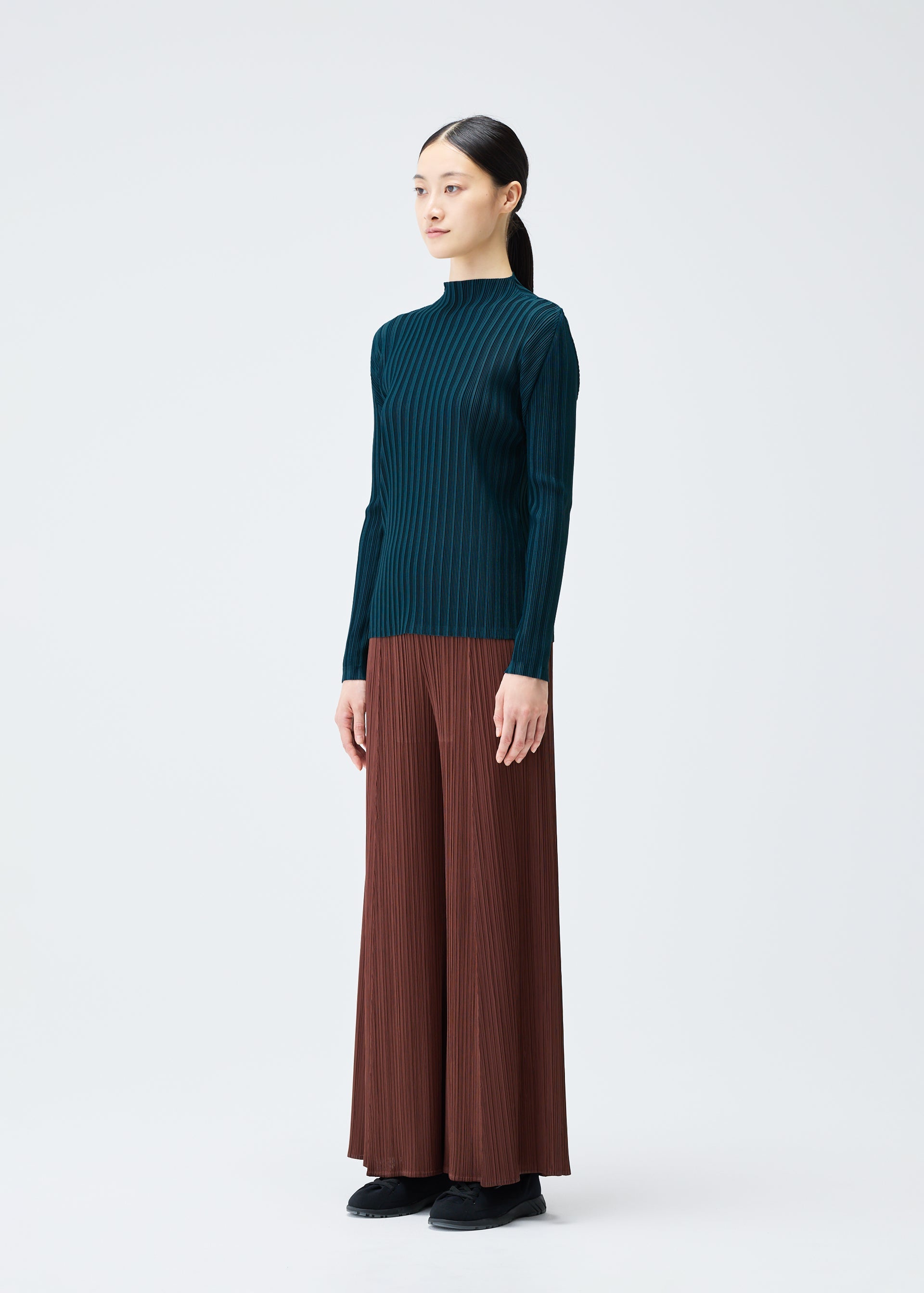 A model wears the PLEATS PLEASE ISSEY MIYAKE RIB PLEATS NOVEMBER top.