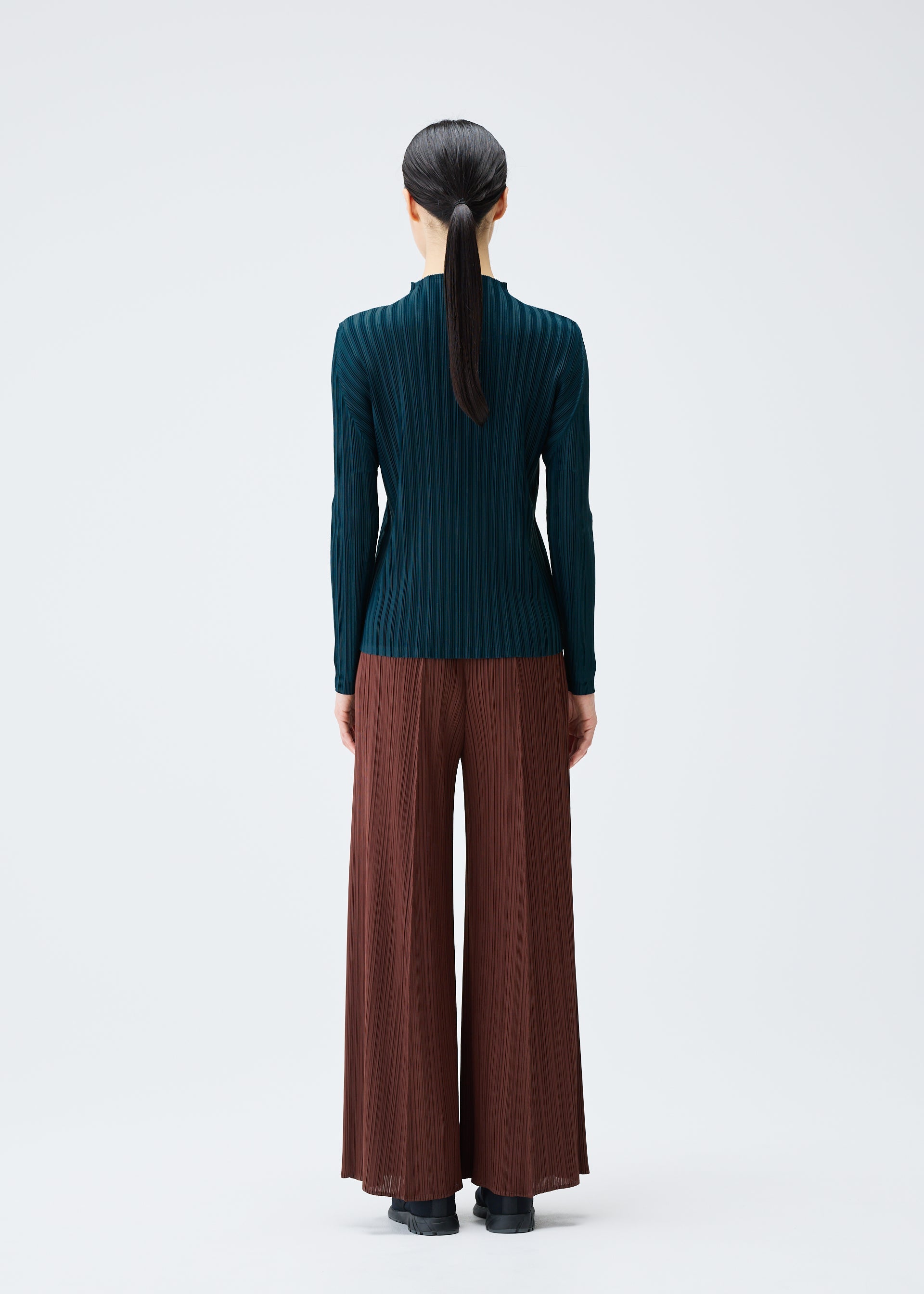 A model wears the PLEATS PLEASE ISSEY MIYAKE RIB PLEATS NOVEMBER top.