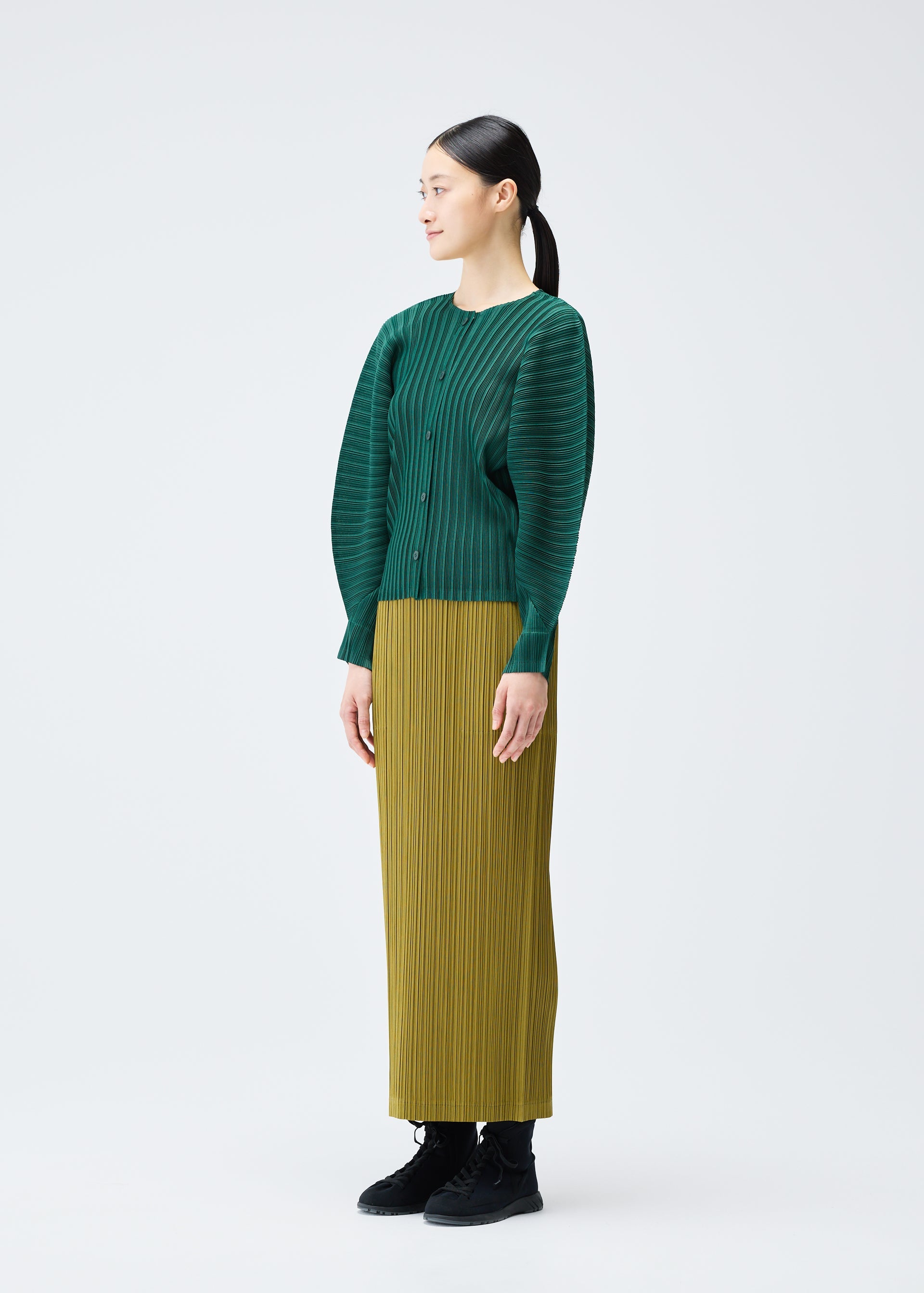 A model wears the PLEATS PLEASE ISSEY MIYAKE RIB PLEATS DECEMBER clothing.