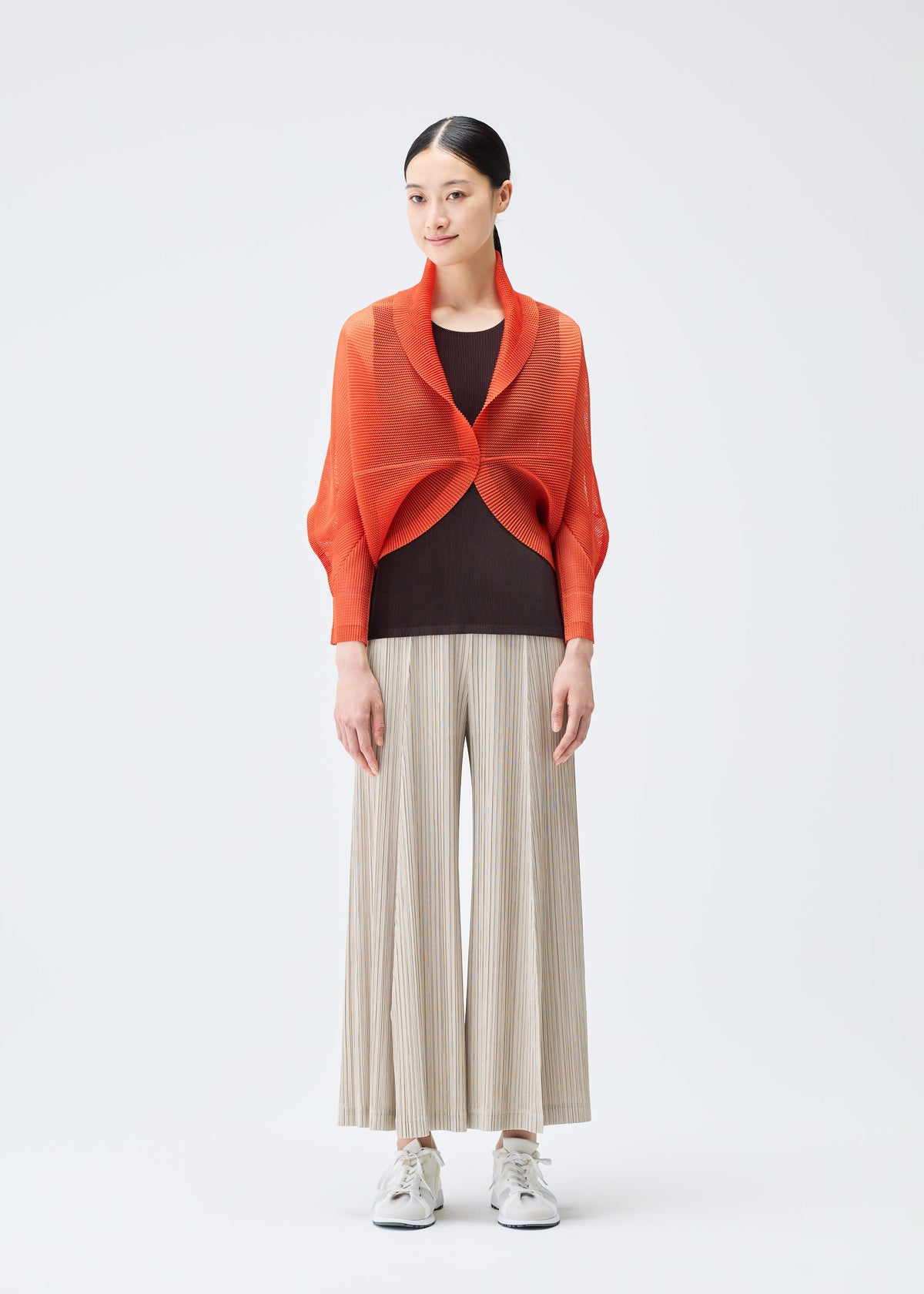 A model wears the PLEATS PLEASE ISSEY MIYAKE TATAMI JULY cardigan.