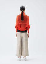 A model wears the PLEATS PLEASE ISSEY MIYAKE TATAMI JULY cardigan.