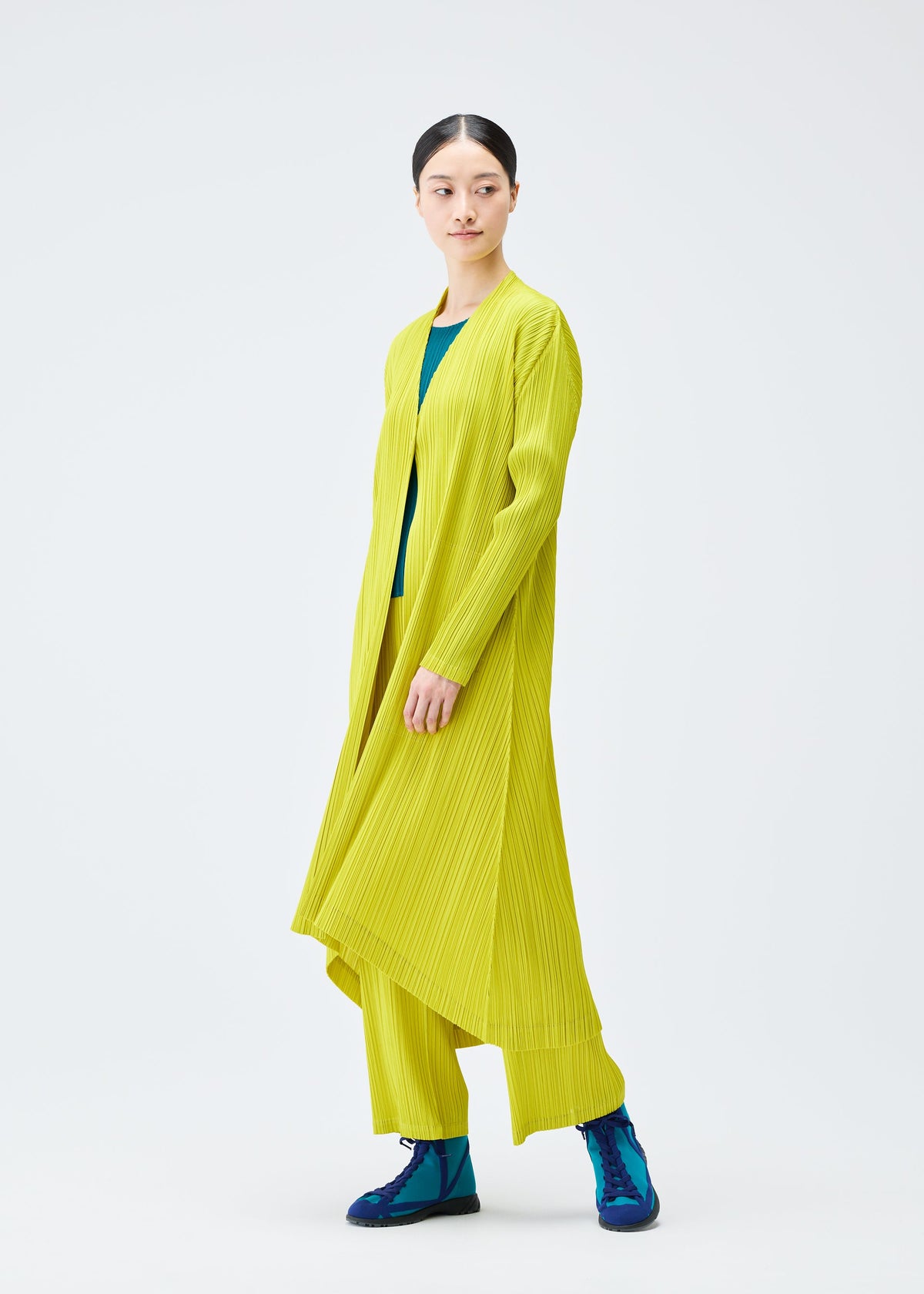 A model wears the PLEATS PLEASE ISSEY MIYAKE MONTHLY COLORS OCTOBER coat.