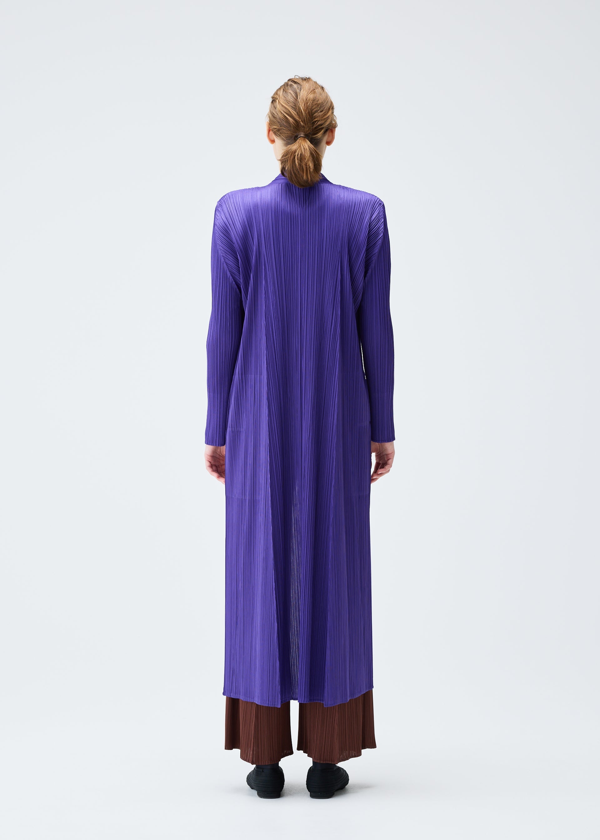 A model wears the PLEATS PLEASE ISSEY MIYAKE MONTHLY COLORS NOVEMBER coat.