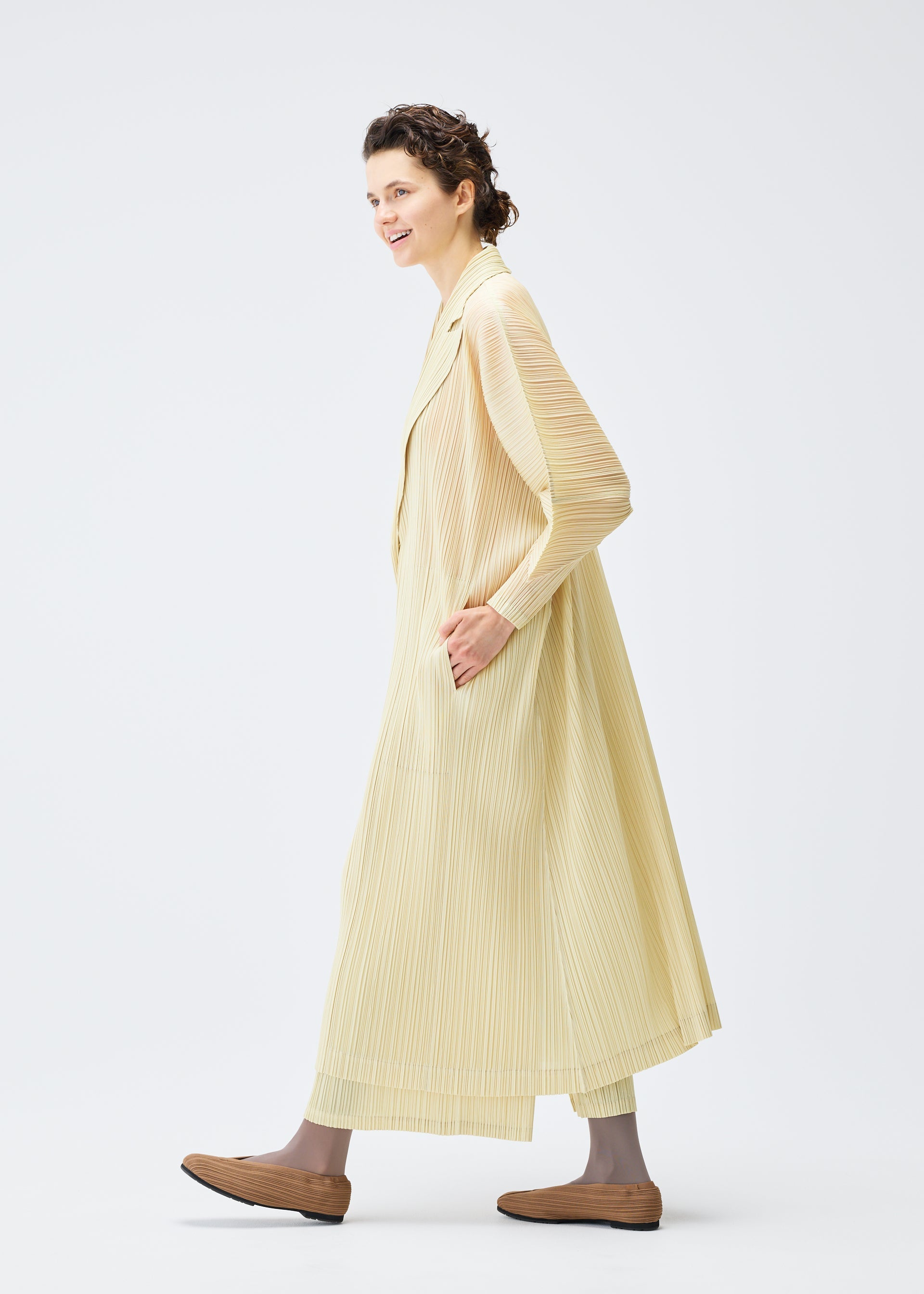 A model wears the PLEATS PLEASE ISSEY MIYAKE MONTHLY COLORS DECEMBER clothing.
