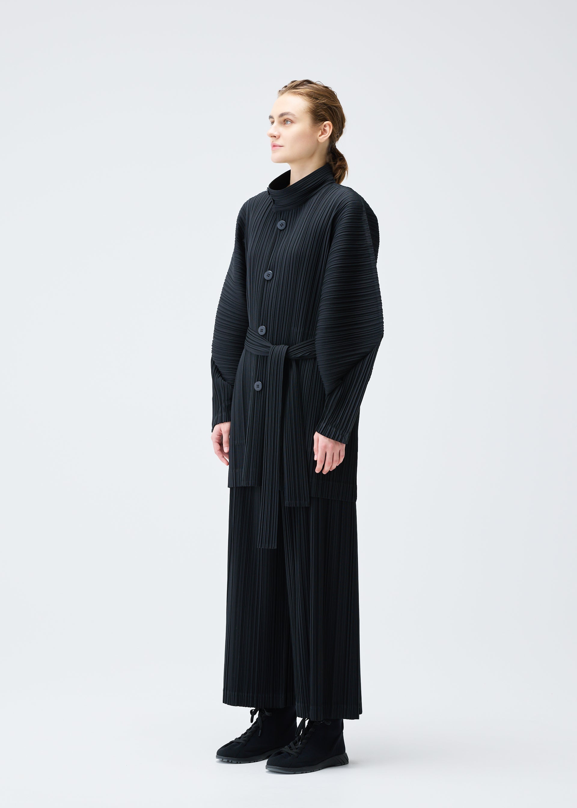 A model wears the PLEATS PLEASE ISSEY MIYAKE WOOL PLEATS coat.
