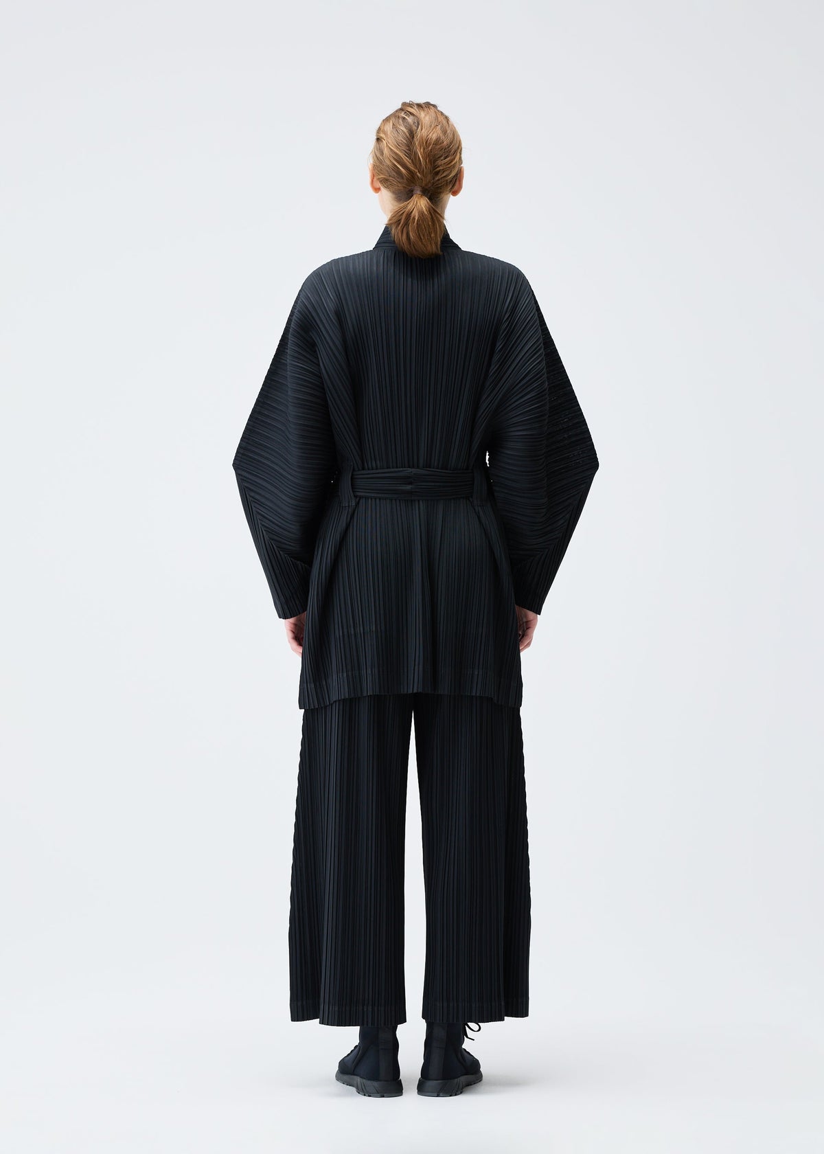 A model wears the PLEATS PLEASE ISSEY MIYAKE WOOL PLEATS coat.