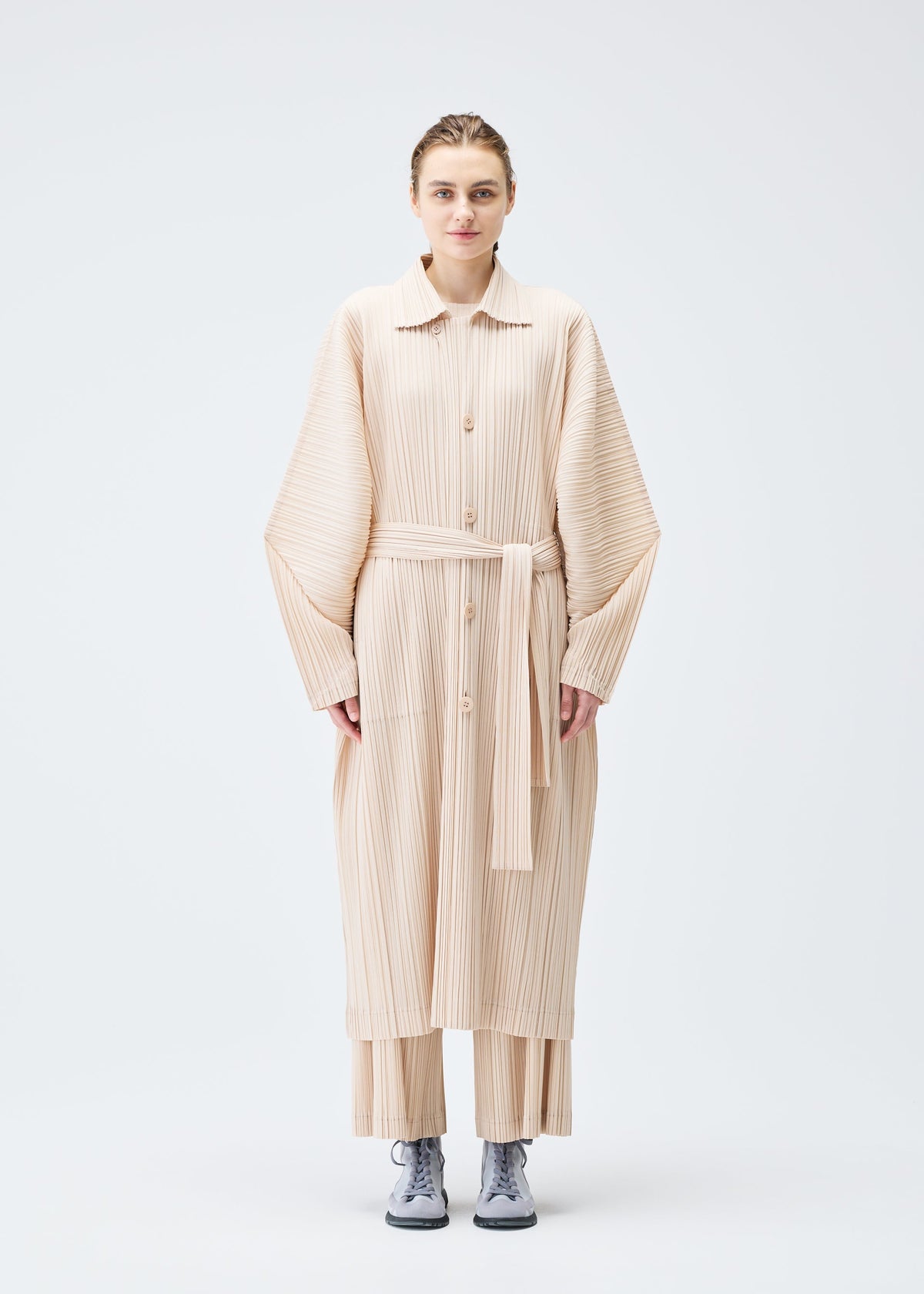 A model wears the PLEATS PLEASE ISSEY MIYAKE WOOL PLEATS coat.