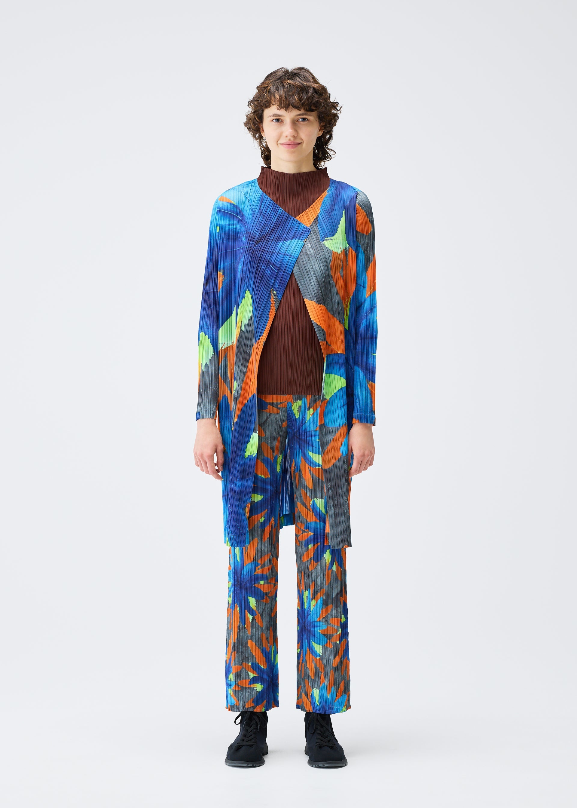 A model wears the PLEATS PLEASE ISSEY MIYAKE CARNIVAL coat.