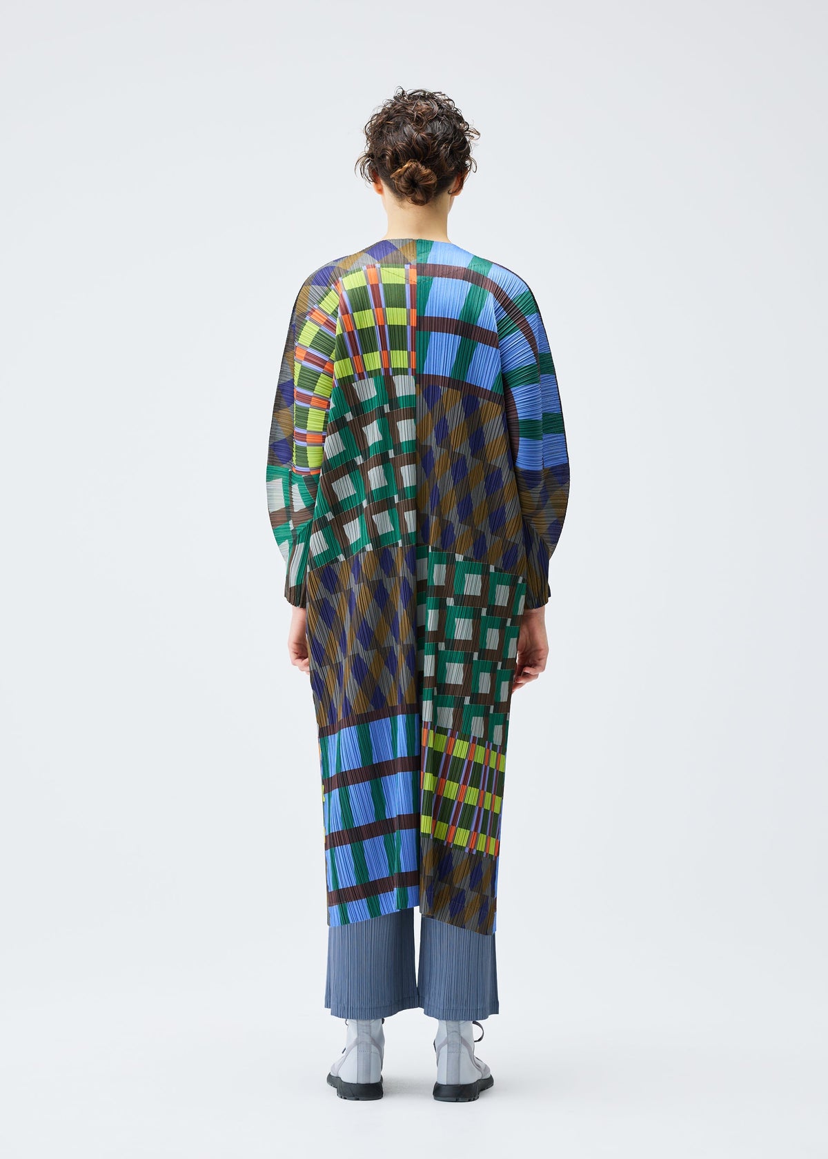 A model wears the PLEATS PLEASE ISSEY MIYAKE HARMONY clothing.