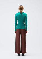 A model wears the PLEATS PLEASE ISSEY MIYAKE MONTHLY COLORS NOVEMBER trousers.