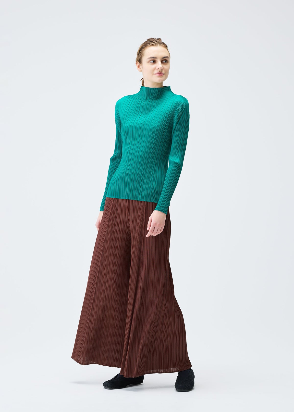 A model wears the PLEATS PLEASE ISSEY MIYAKE MONTHLY COLORS NOVEMBER trousers.