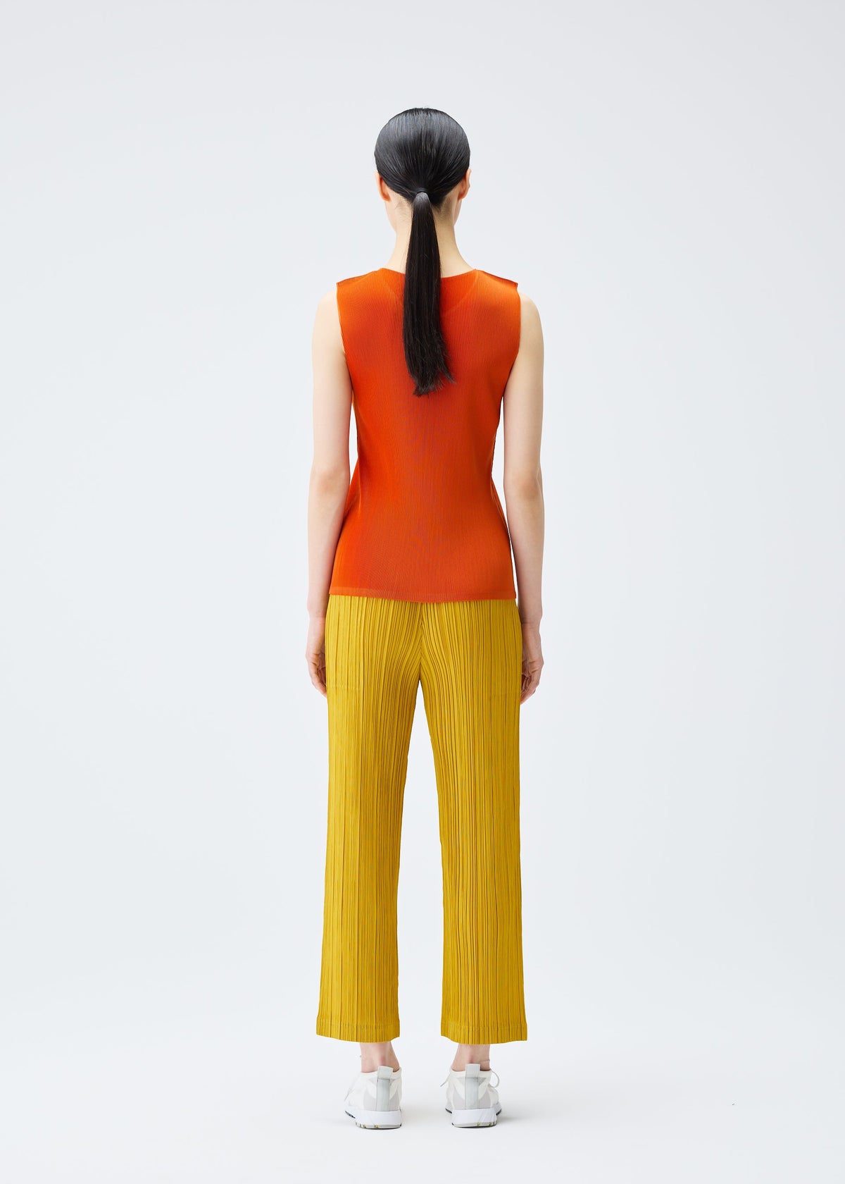 A model wears the PLEATS PLEASE ISSEY MIYAKE THICKER BOTTOMS 1 trousers.