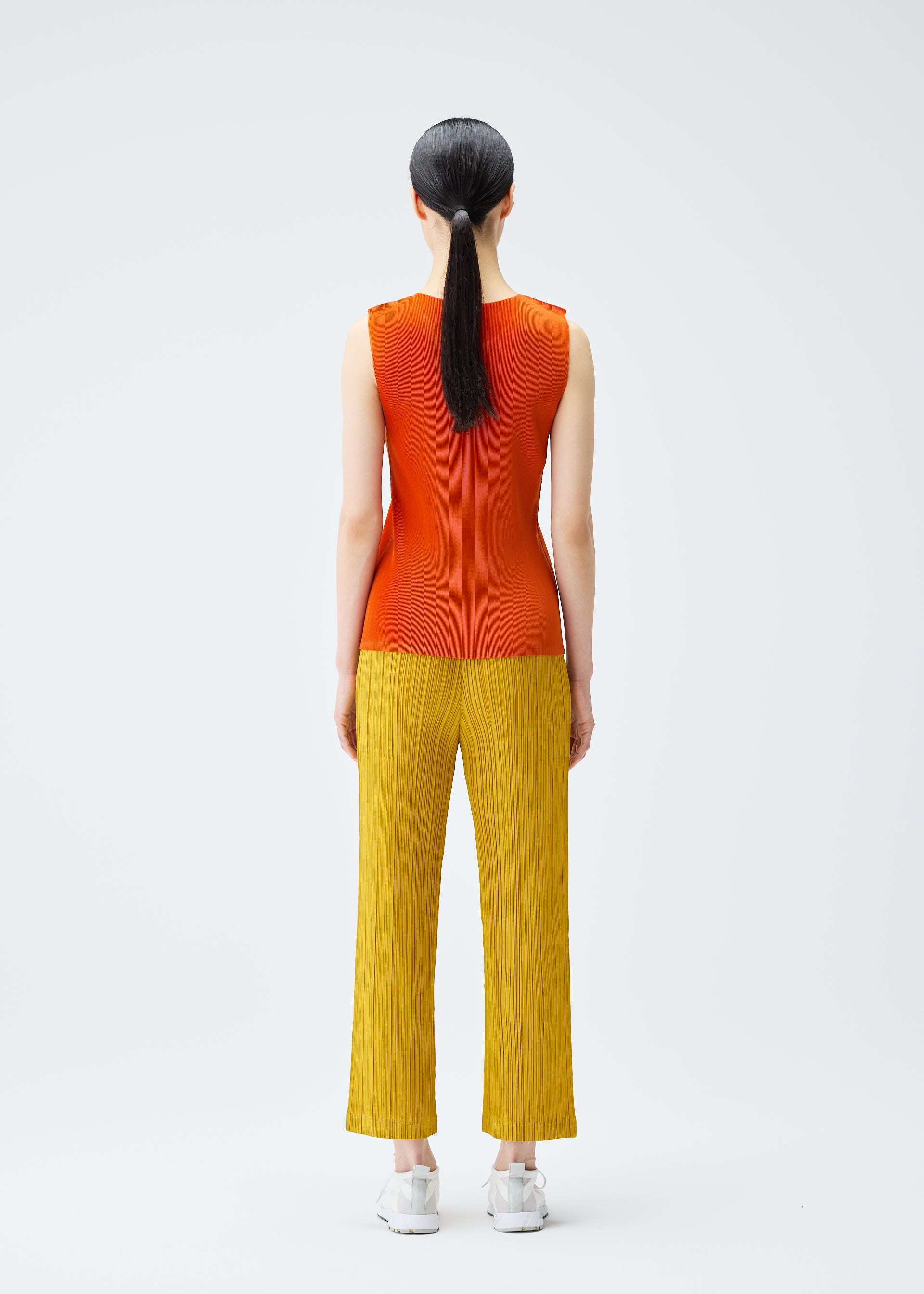 A model wears the PLEATS PLEASE ISSEY MIYAKE THICKER BOTTOMS 1 trousers.