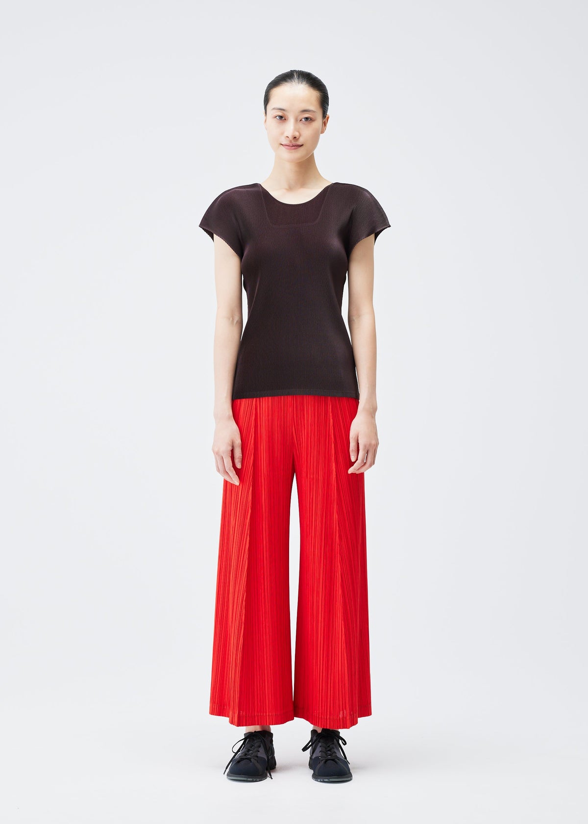 A model wears the PLEATS PLEASE ISSEY MIYAKE THICKER BOTTOMS 1 trousers.