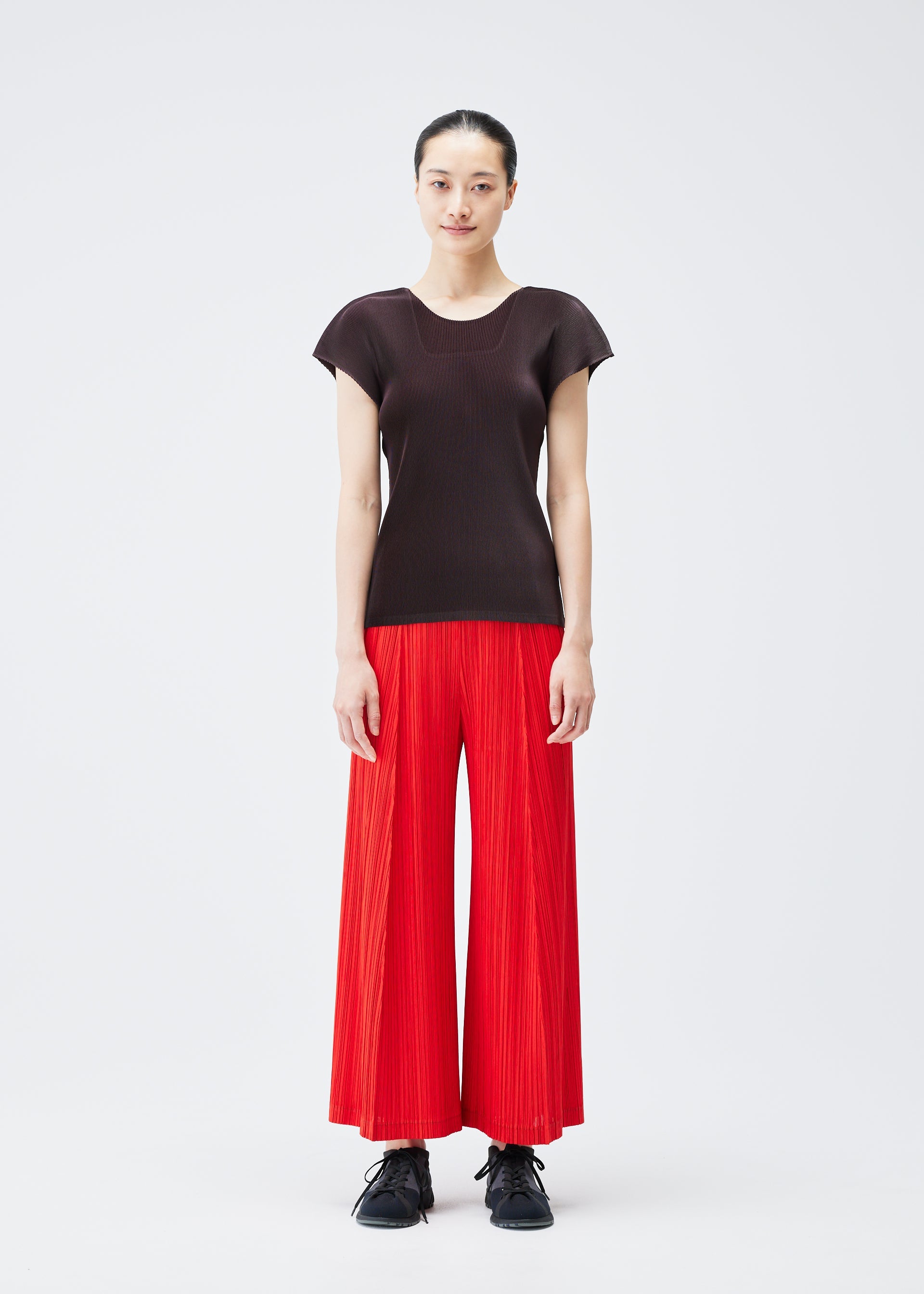 A model wears the PLEATS PLEASE ISSEY MIYAKE THICKER BOTTOMS 1 trousers.