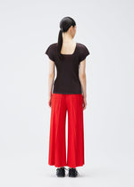 A model wears the PLEATS PLEASE ISSEY MIYAKE THICKER BOTTOMS 1 trousers.