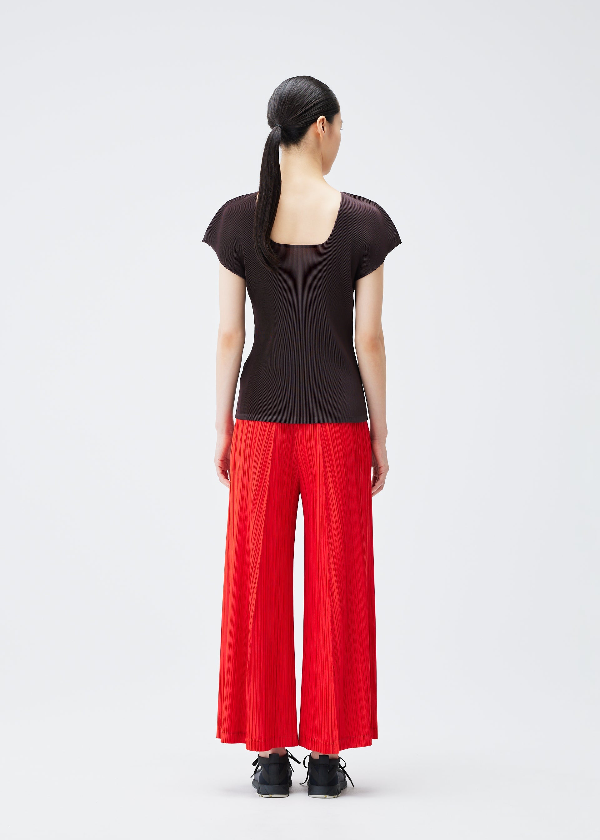 A model wears the PLEATS PLEASE ISSEY MIYAKE THICKER BOTTOMS 1 trousers.