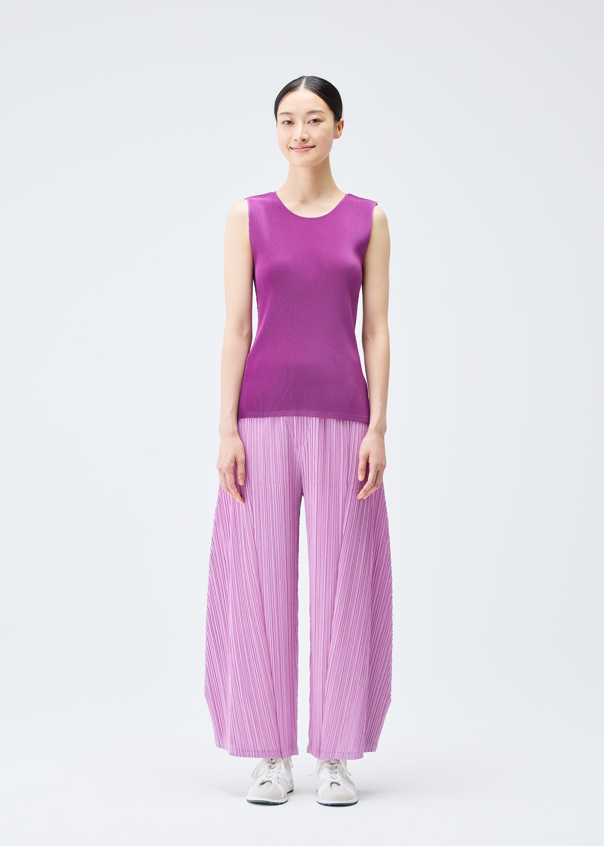 A model wears the PLEATS PLEASE ISSEY MIYAKE THICKER BOTTOMS 2 trousers.