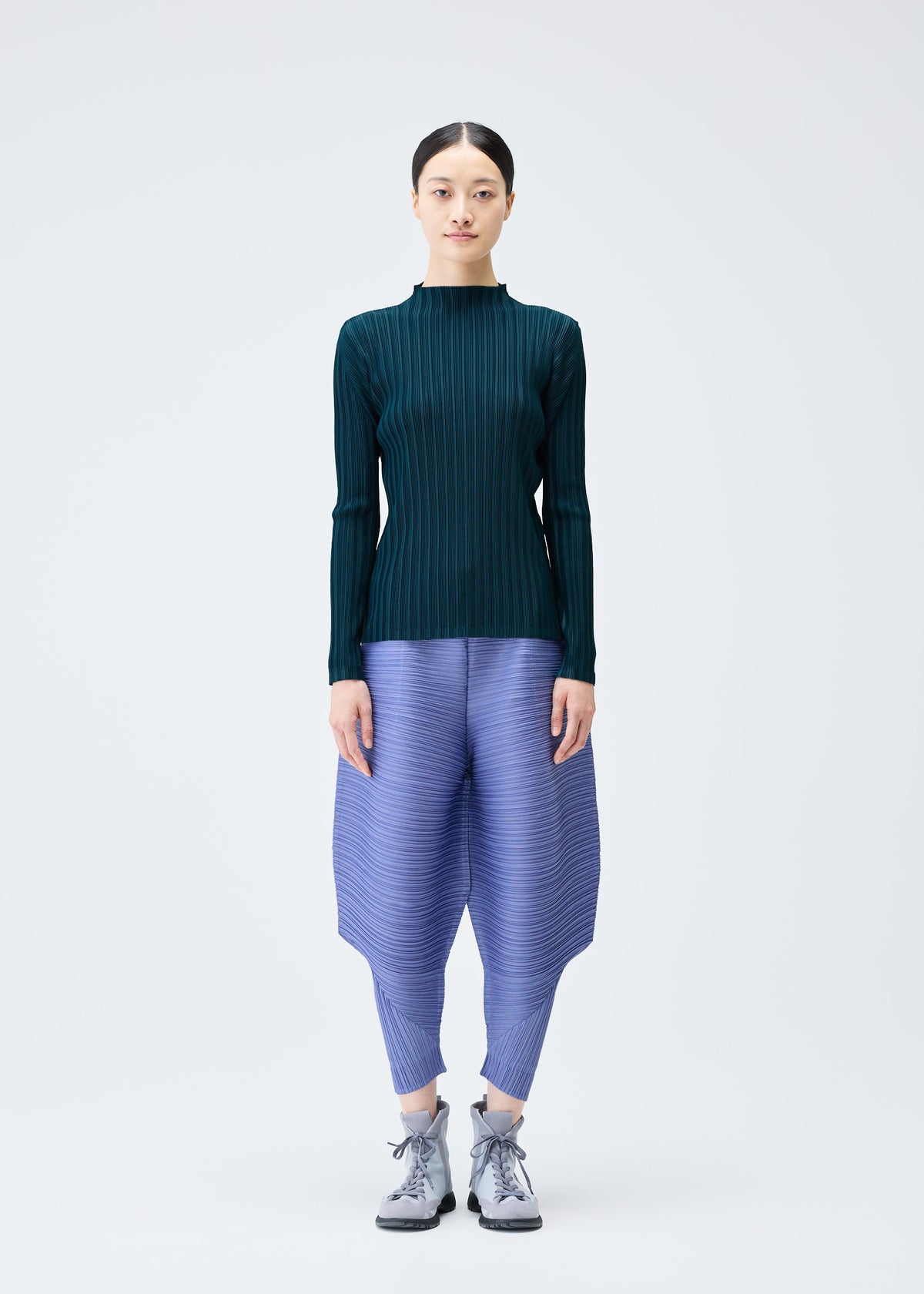 A model wears the PLEATS PLEASE ISSEY MIYAKE THICKER BOUNCE trousers.