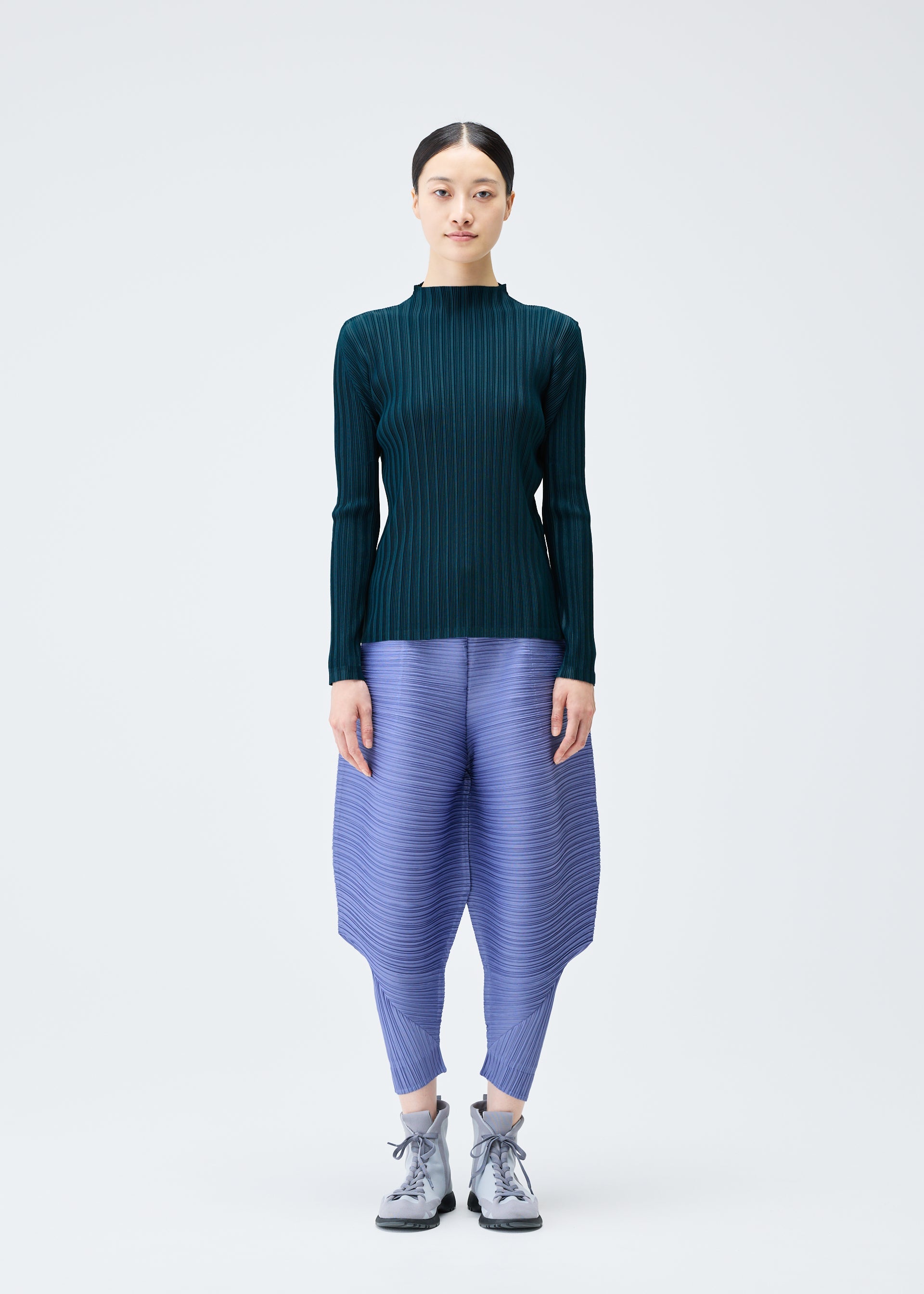 A model wears the PLEATS PLEASE ISSEY MIYAKE THICKER BOUNCE trousers.
