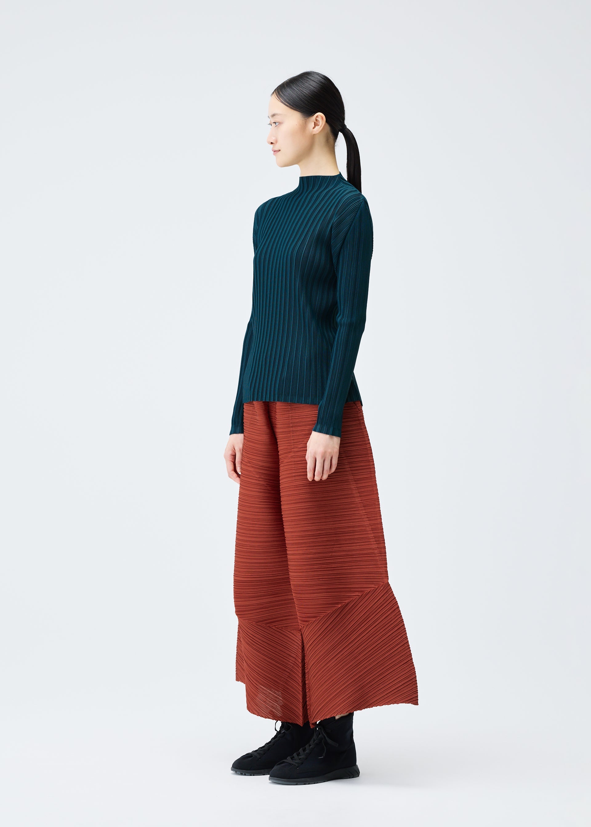 A model wears the PLEATS PLEASE ISSEY MIYAKE THICKER BOUNCE trousers.