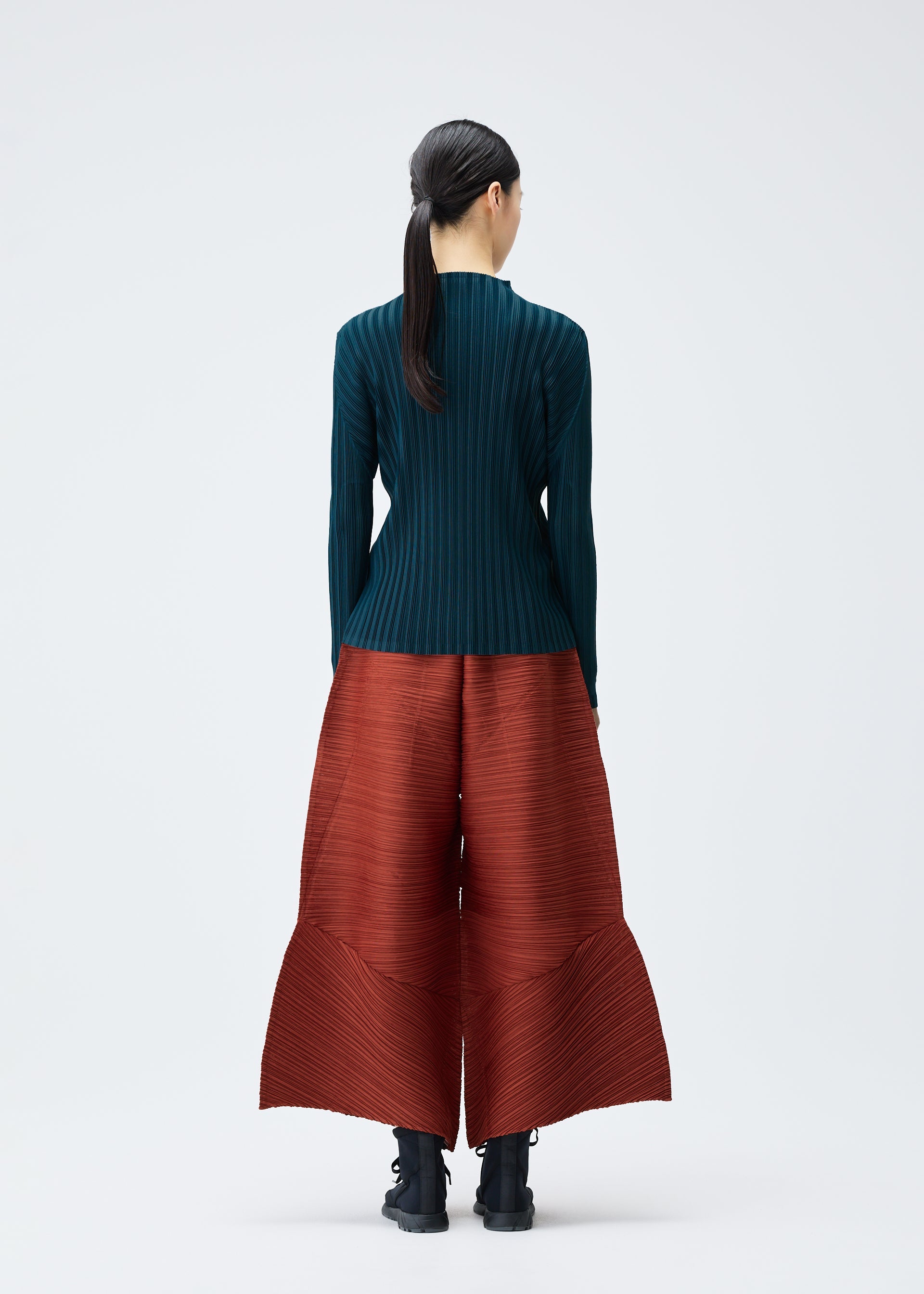 A model wears the PLEATS PLEASE ISSEY MIYAKE THICKER BOUNCE trousers.