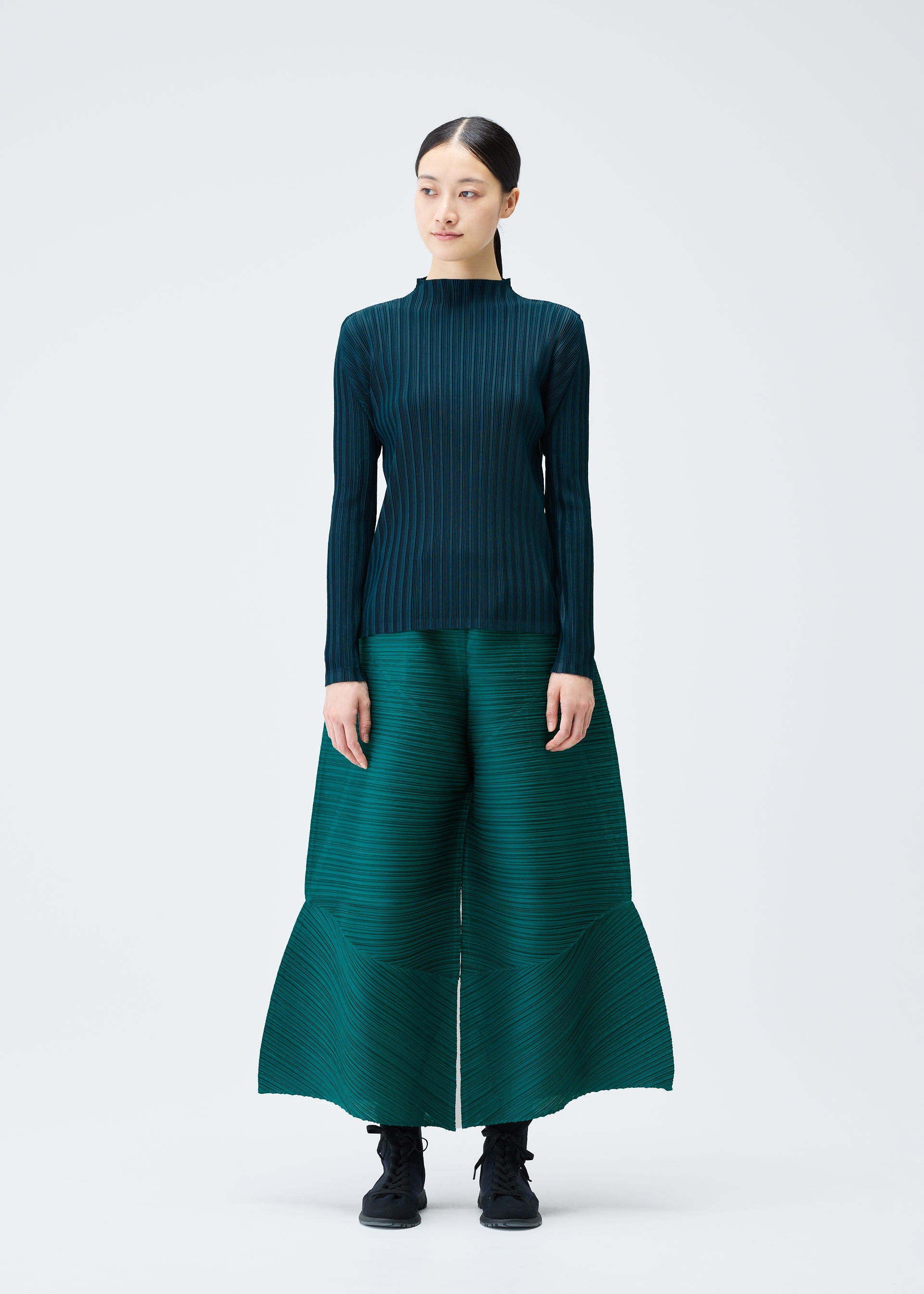 A model wears the PLEATS PLEASE ISSEY MIYAKE THICKER BOUNCE trousers.