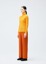 A model wears the PLEATS PLEASE ISSEY MIYAKE LOOP BOTTOMS clothing.