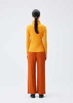 A model wears the PLEATS PLEASE ISSEY MIYAKE LOOP BOTTOMS clothing.